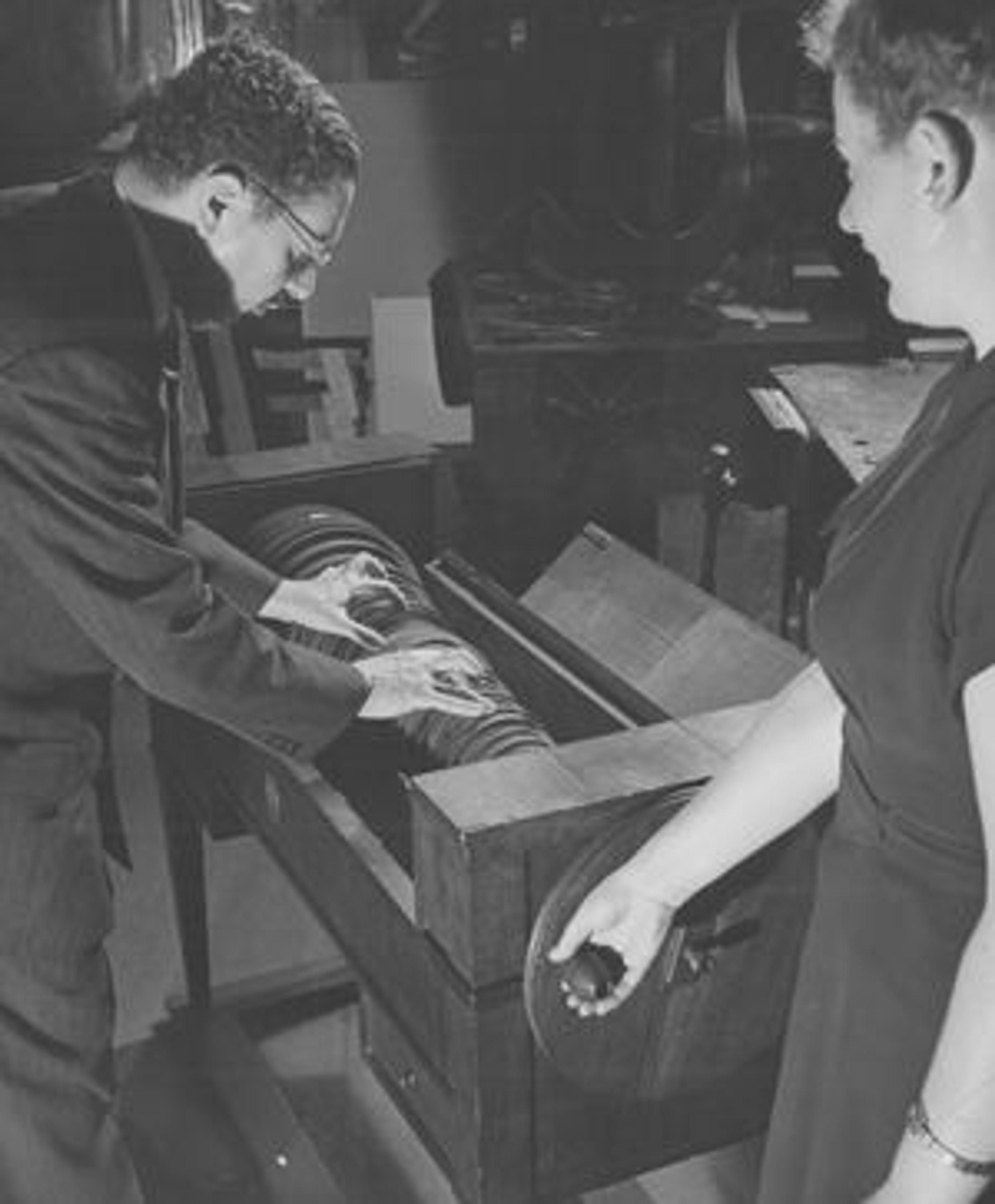 Winternitz in the long-closed instrument galleries in the early 1940s, playing a glass armonica.  Departmental Assistant Sofula Novikova is seen turning the cylinder.