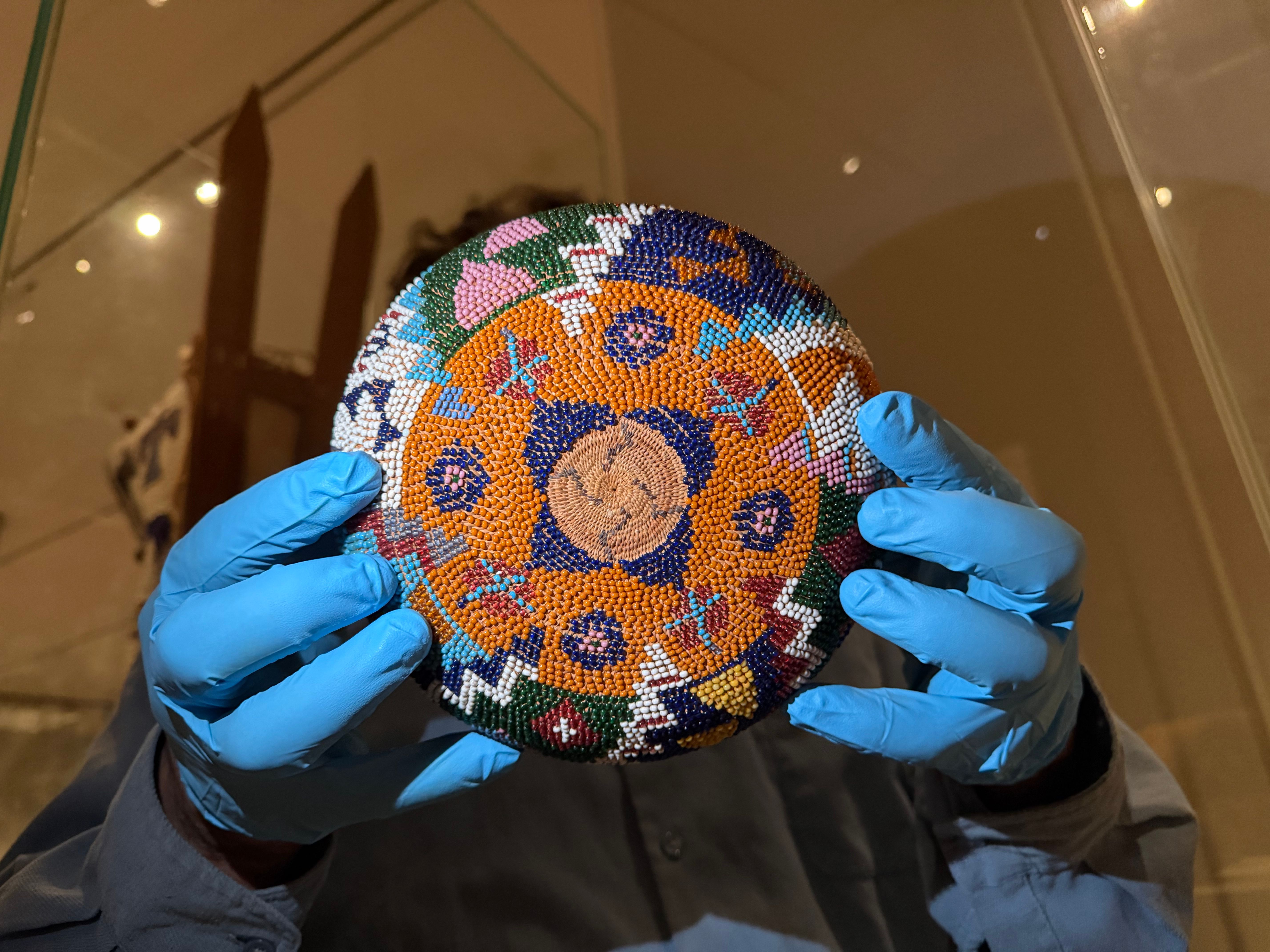 hands in blue gloves holding up a woven basket