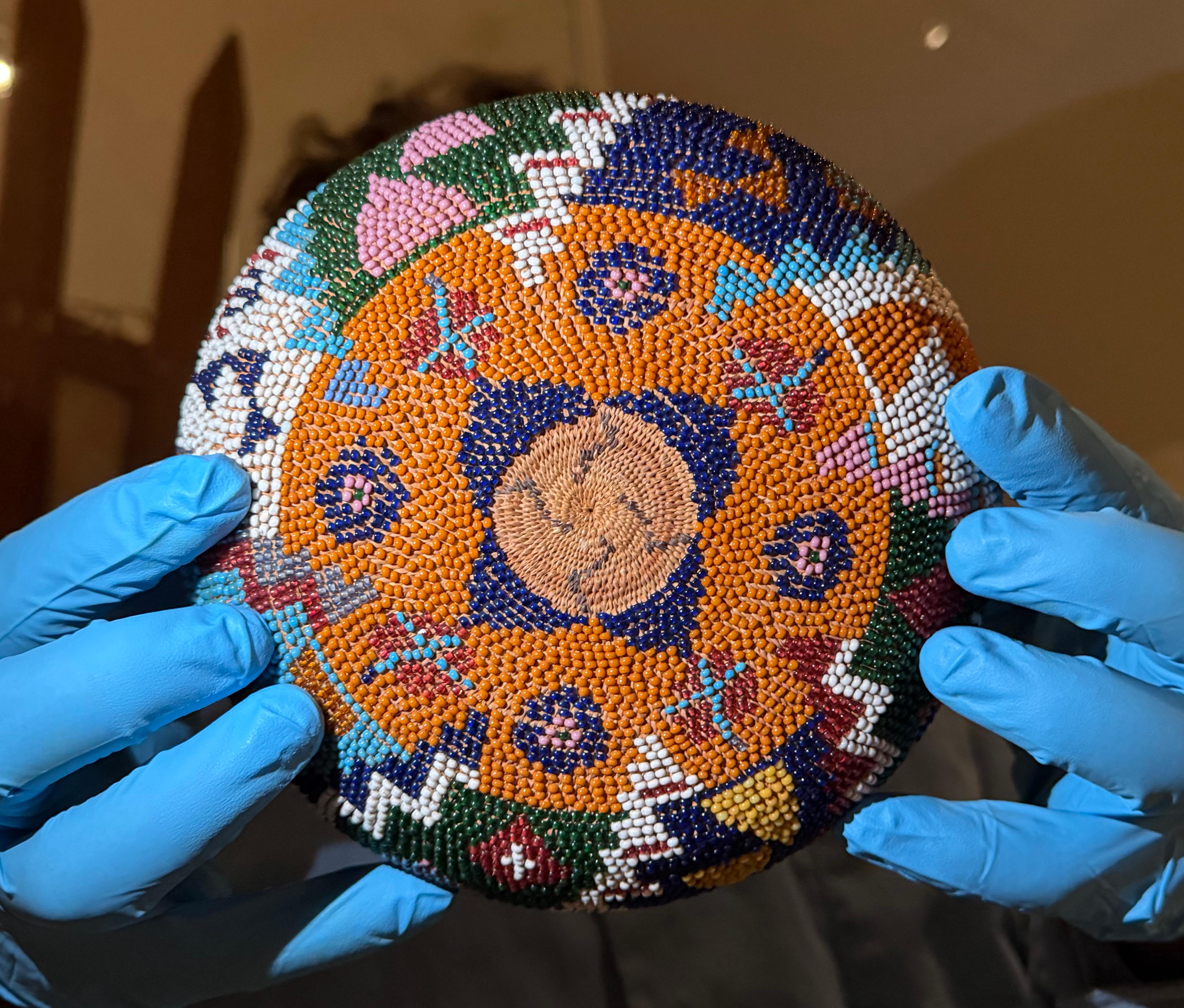 hands in blue gloves holding up a woven basket