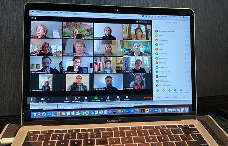 A laptop computer displays a zoom conversation with many participants and 16 visible speakers.