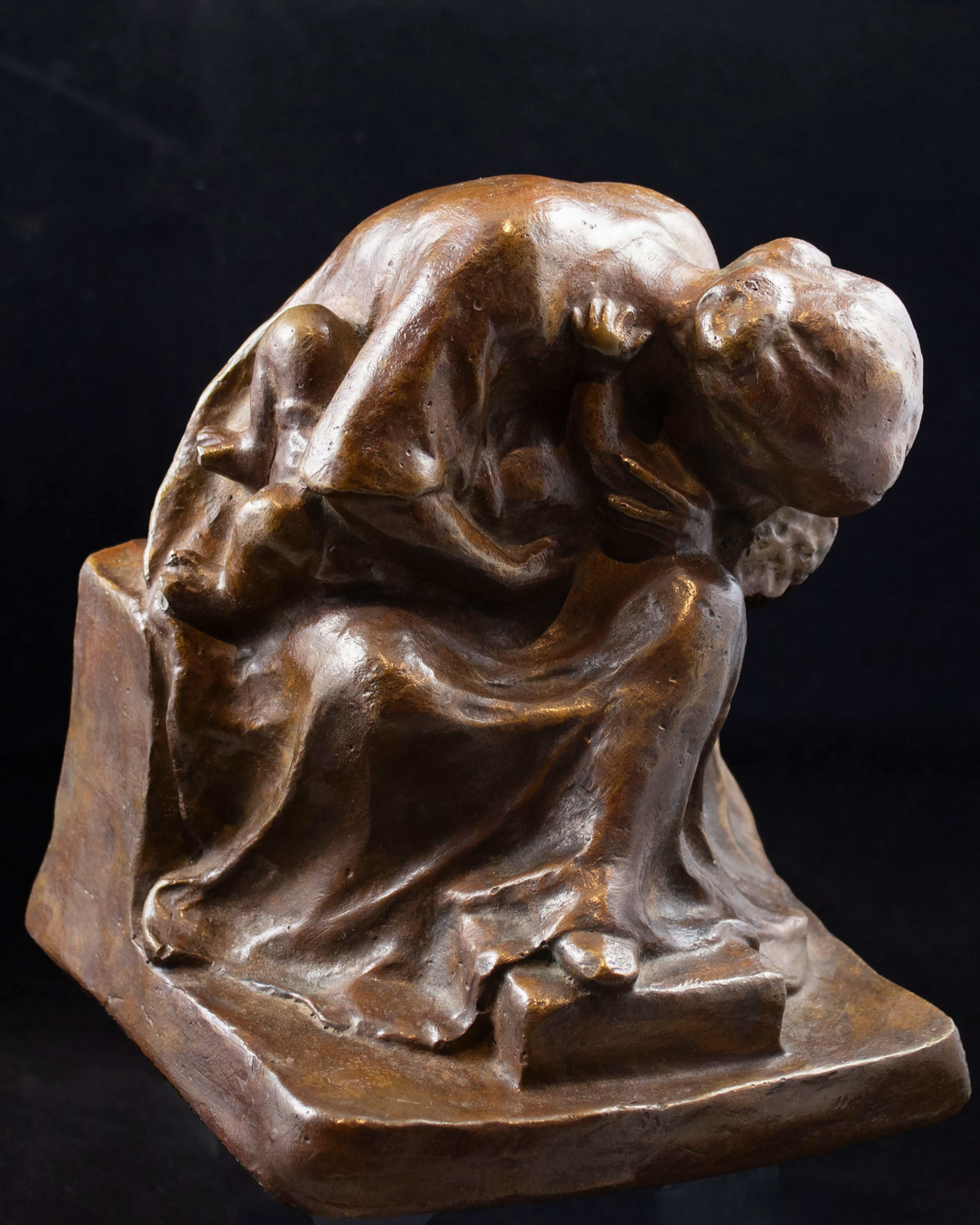 Bronze sculpture of a seated woman in a contemplative pose, with a shawl over her head. Her form is rounded and textured.