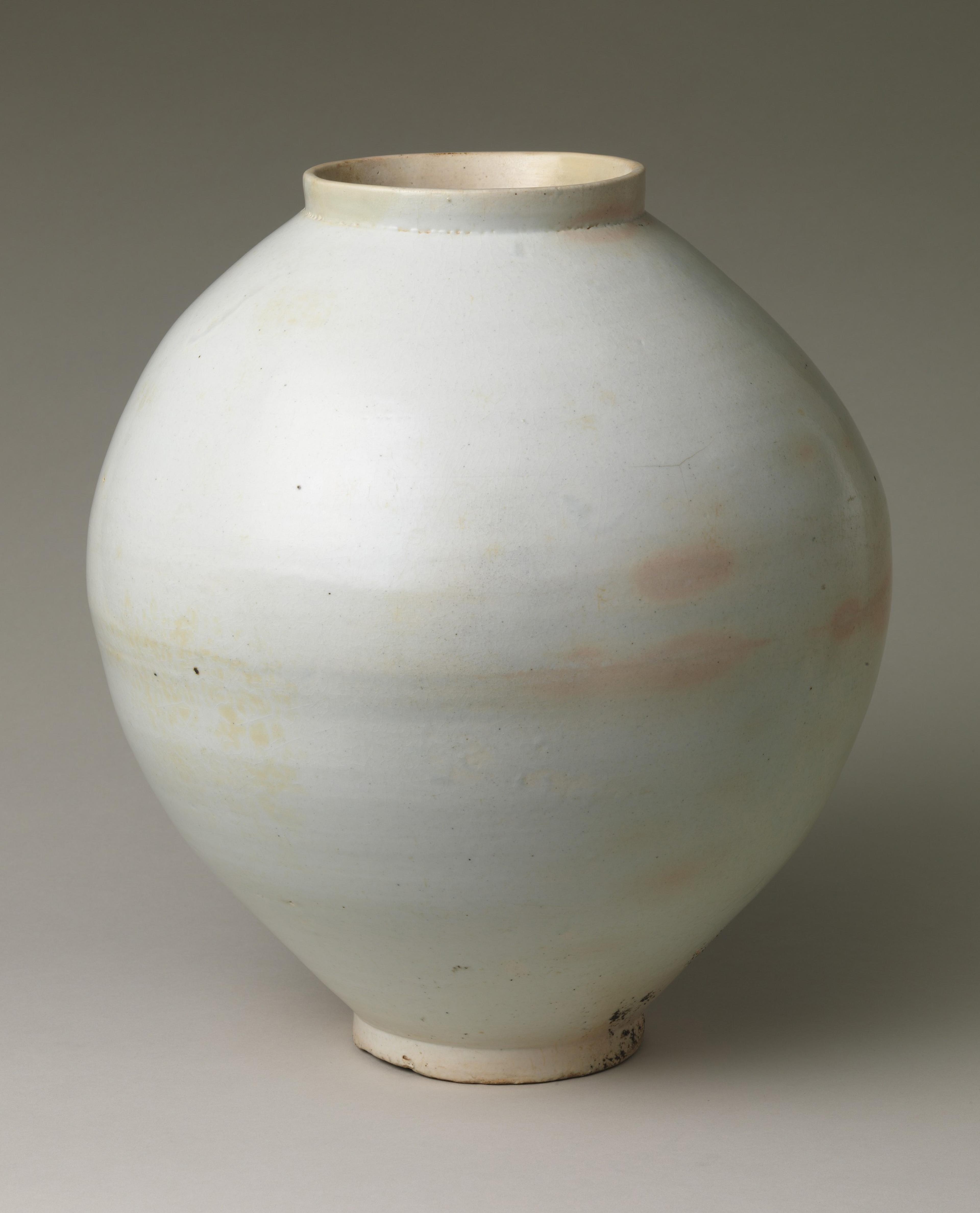 White porcelain jar with an asymmetrically rounded body, narrow foot, and cylindrical neck.