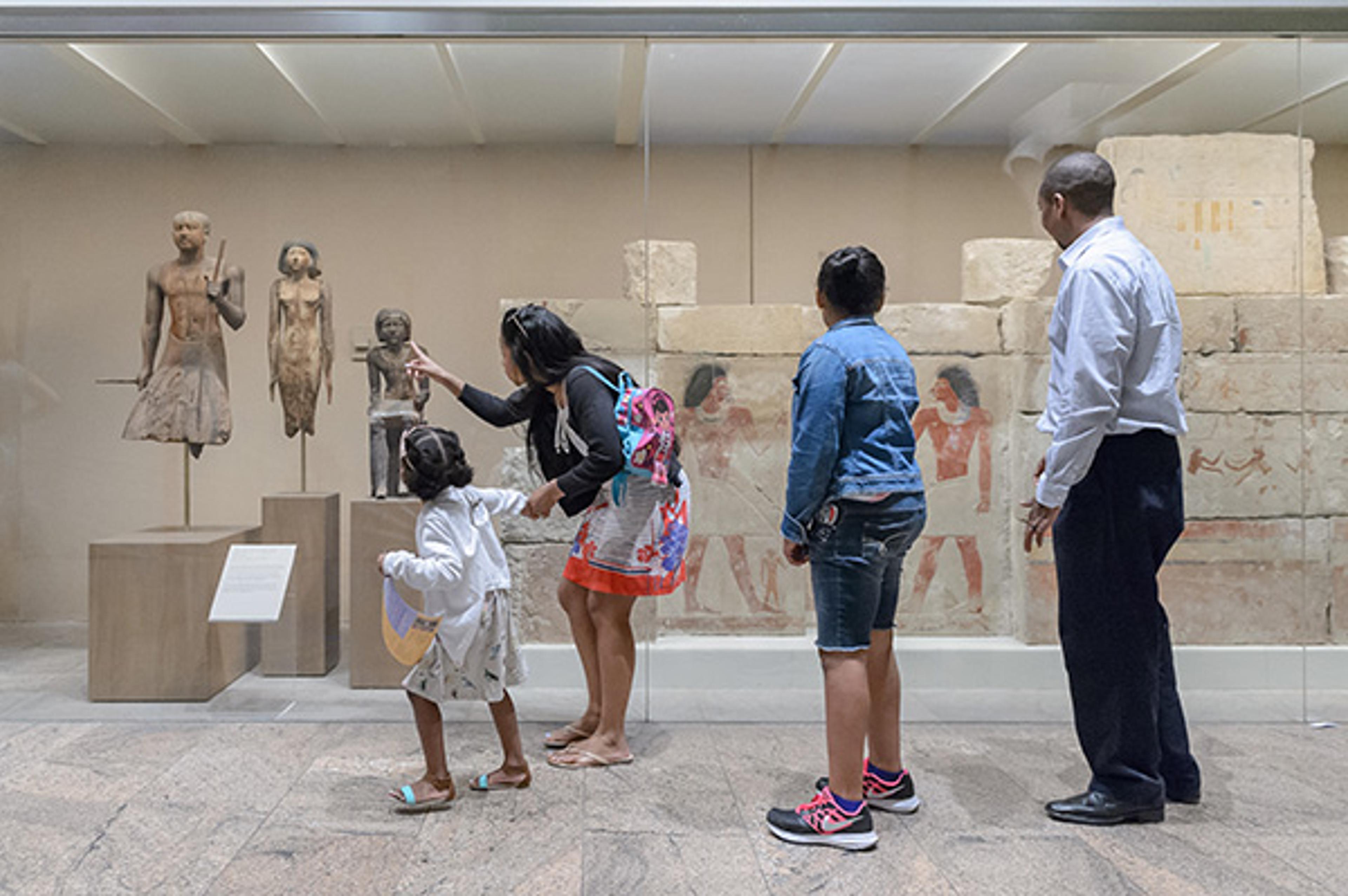 A mother walks with her daughter through the Egyptian galleries