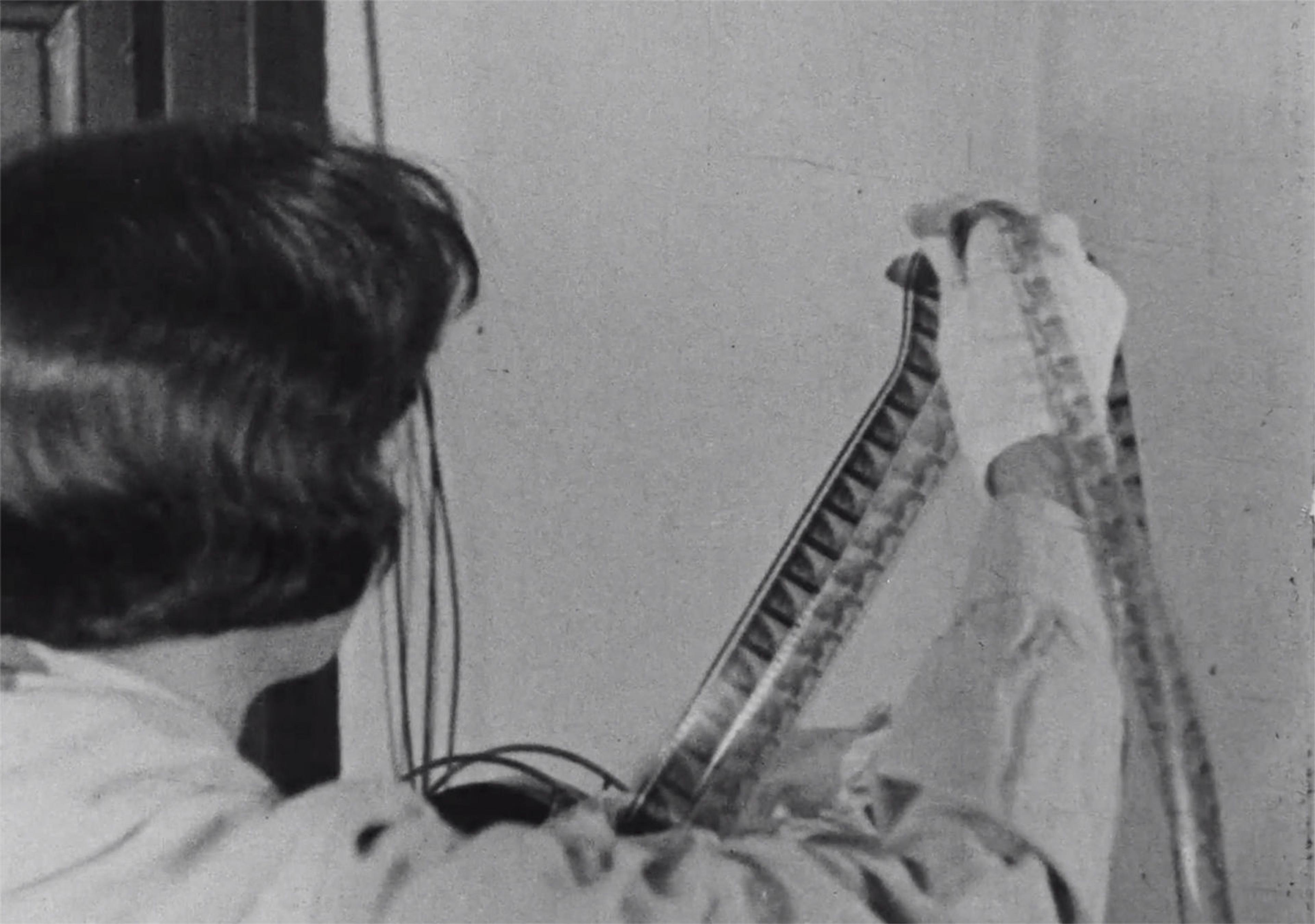 A woman examines a film strip