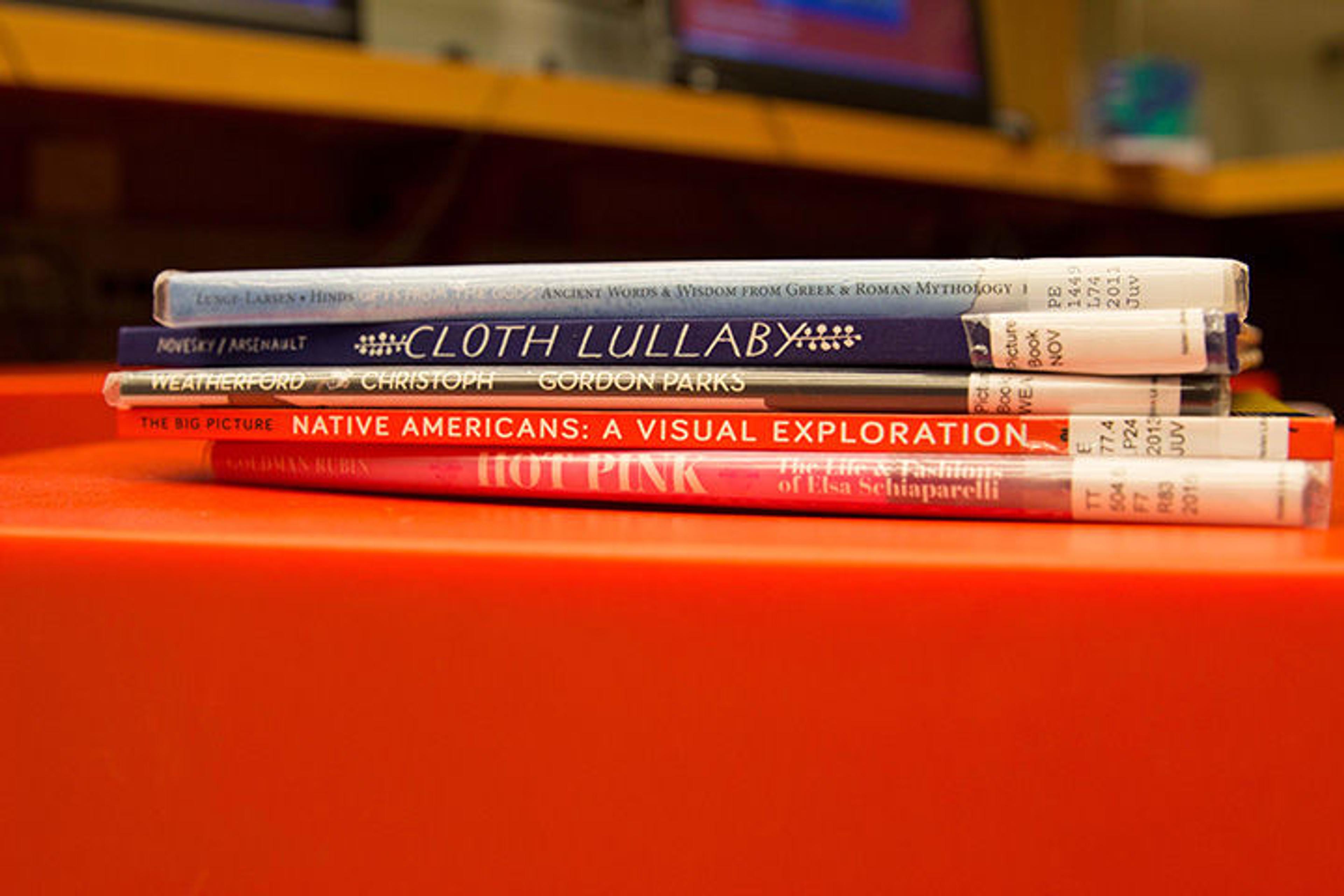 Five books stacked on a red table