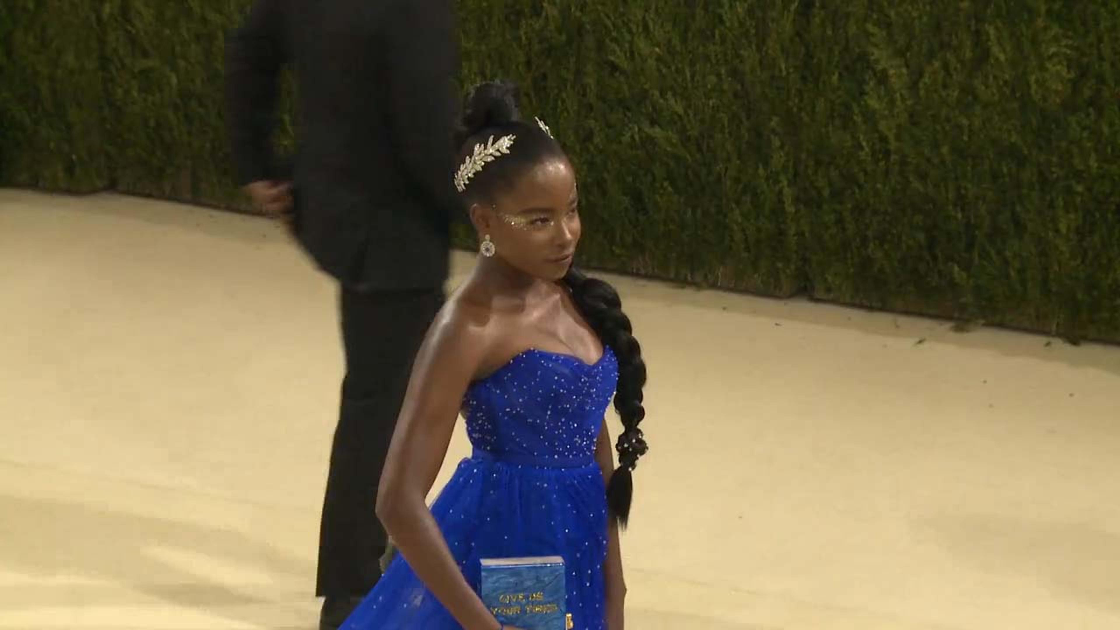 Amanda Gorman arriving on the 2021 Met Gala red carpet in a blue dress and gold leaf crown.