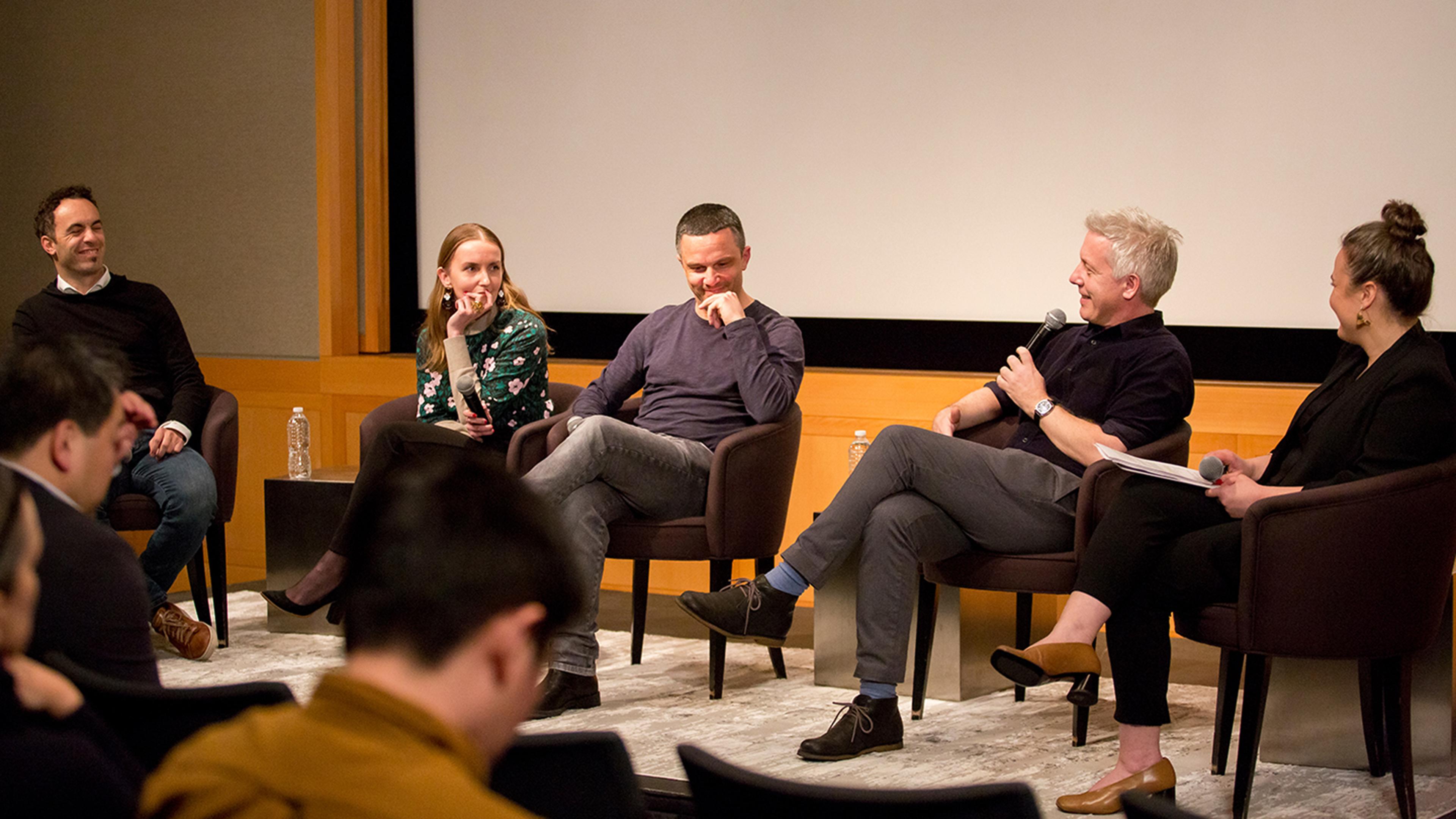 A group of panelists in a large auditorium