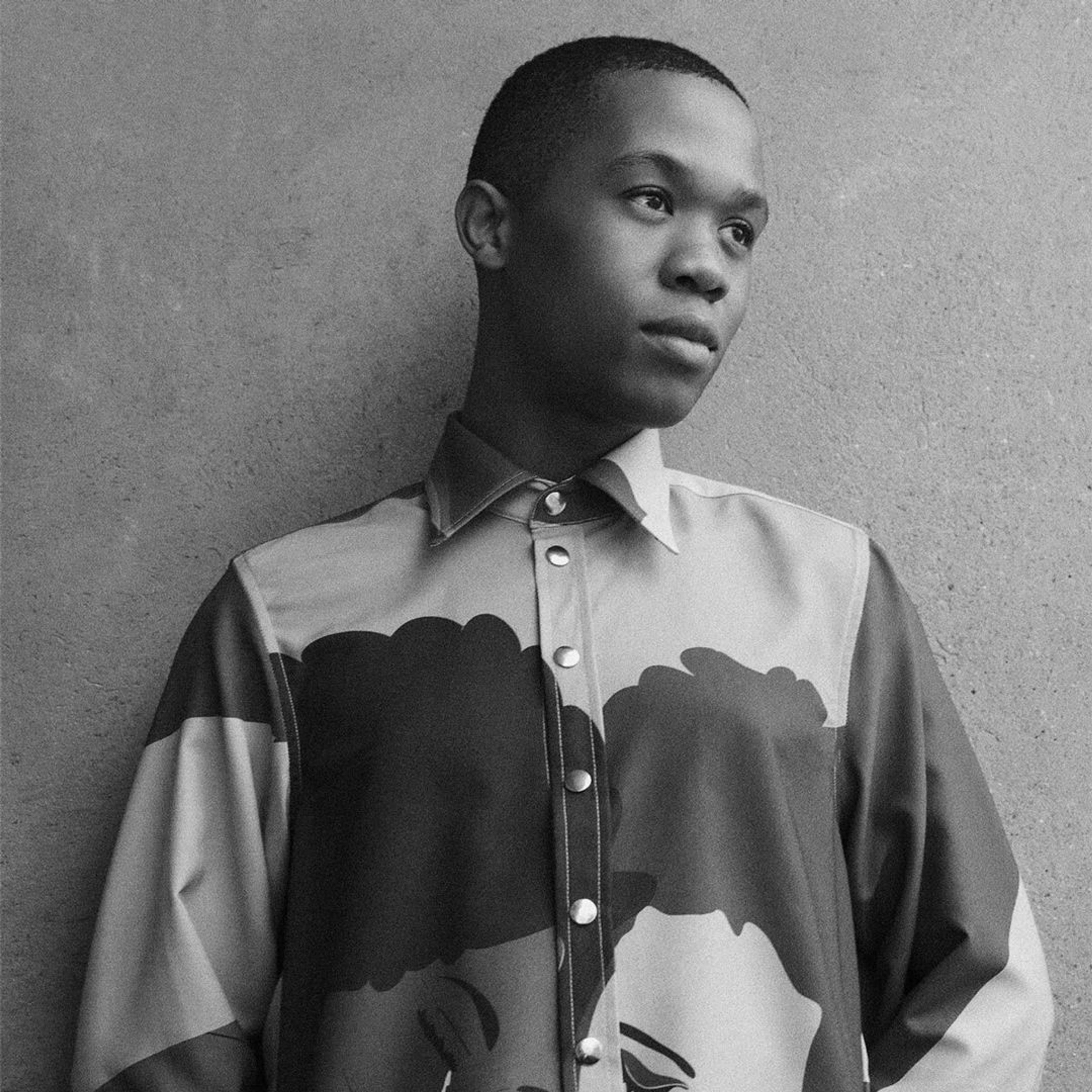 The designer Thebe Magugu wearing a shirt depicting two women seated next to each other
