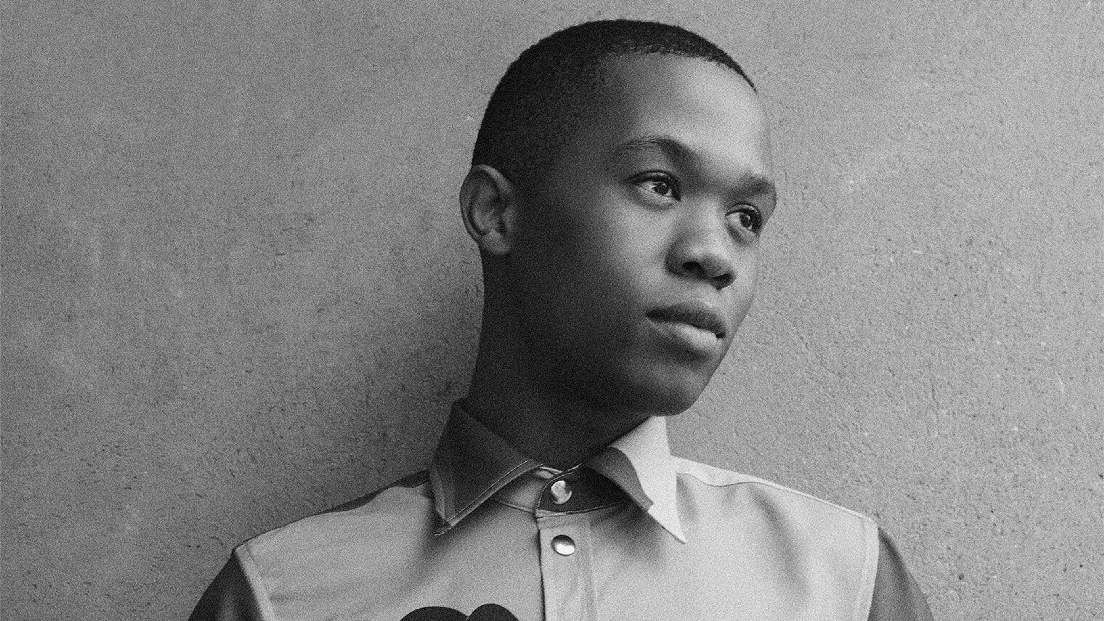 The designer Thebe Magugu wearing a shirt depicting two women seated next to each other