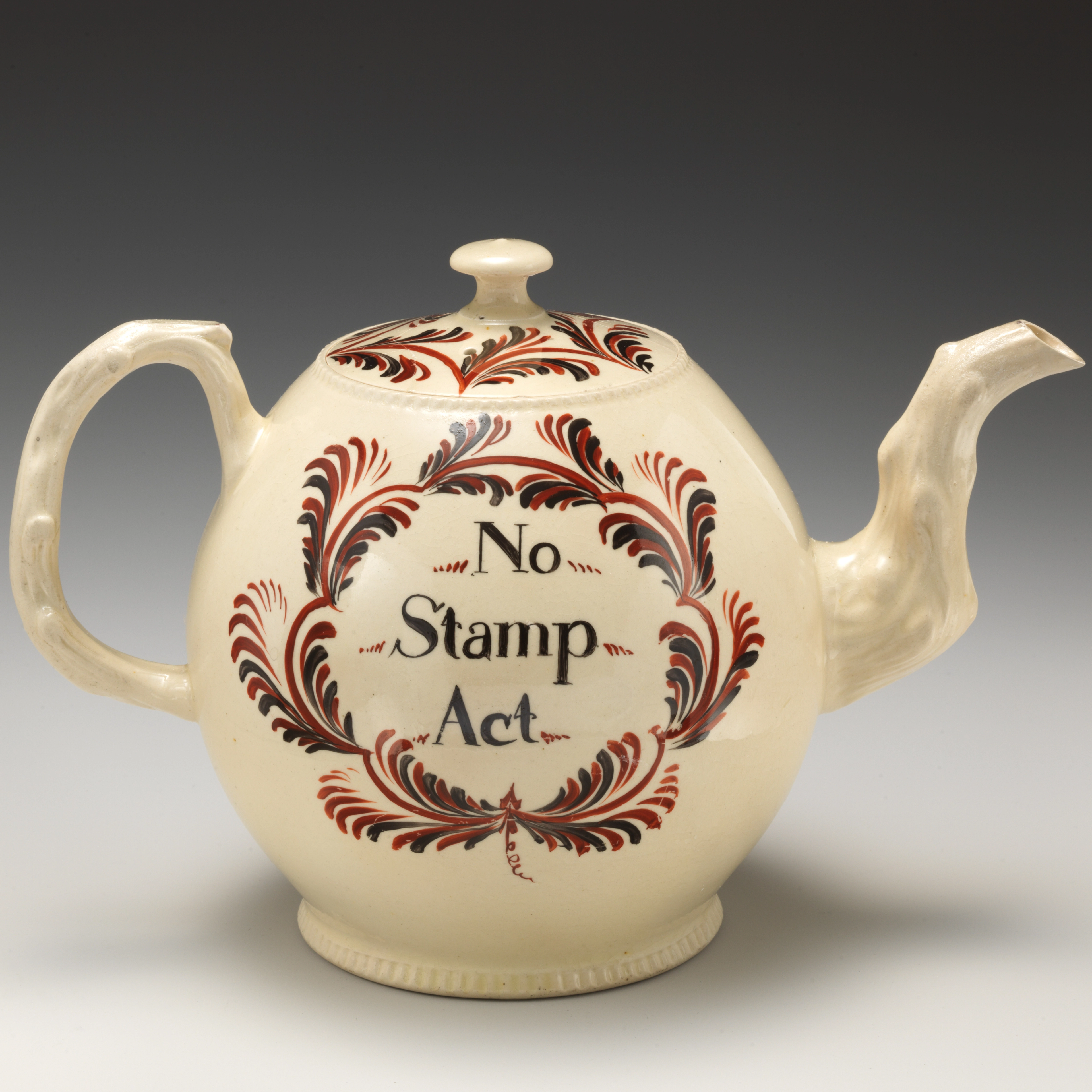 Cream-colored teapot with a black and red design around the words "No Stamp Act."