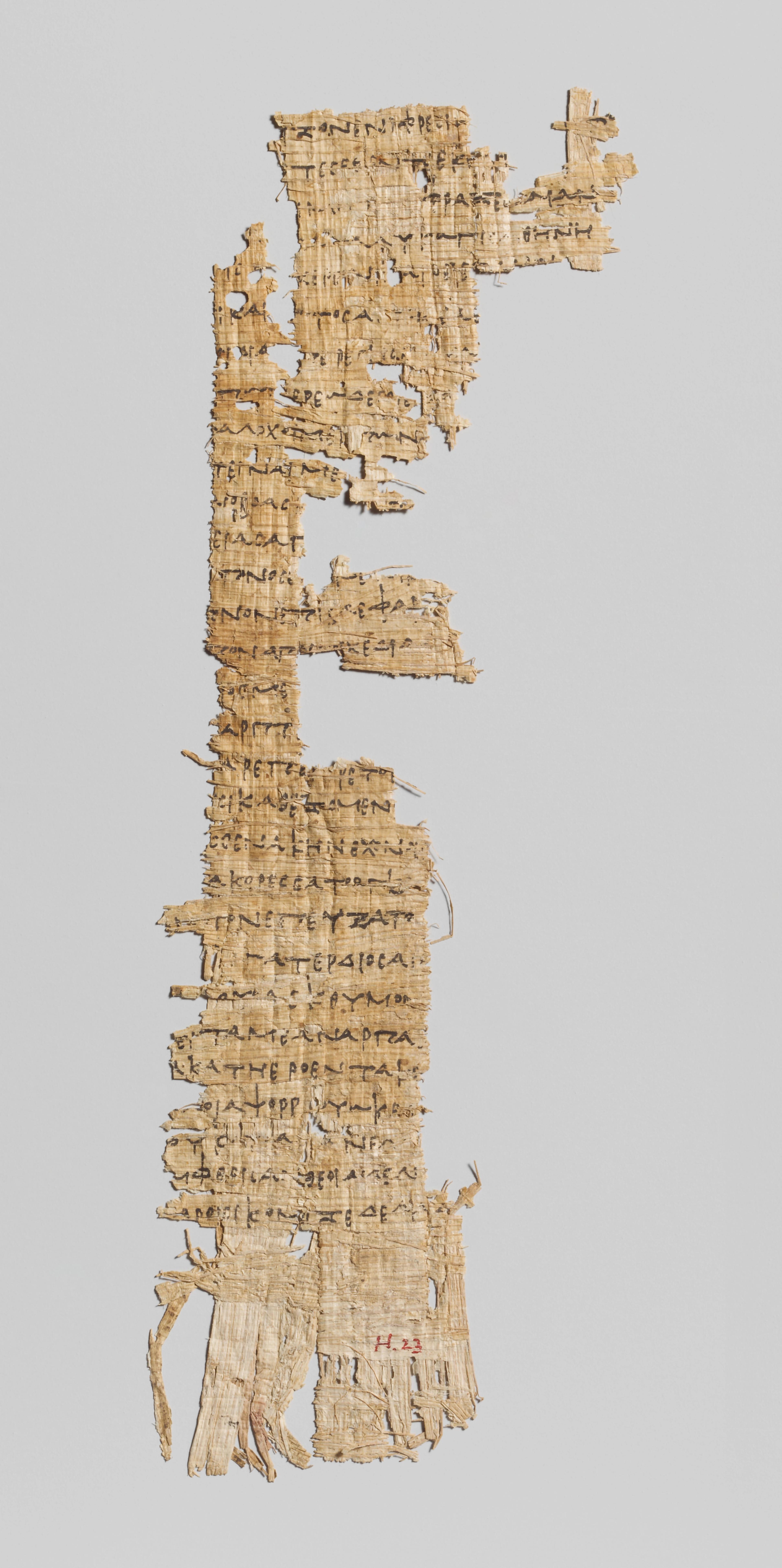 Heavily damaged piece of papyrus marked with writing in black.