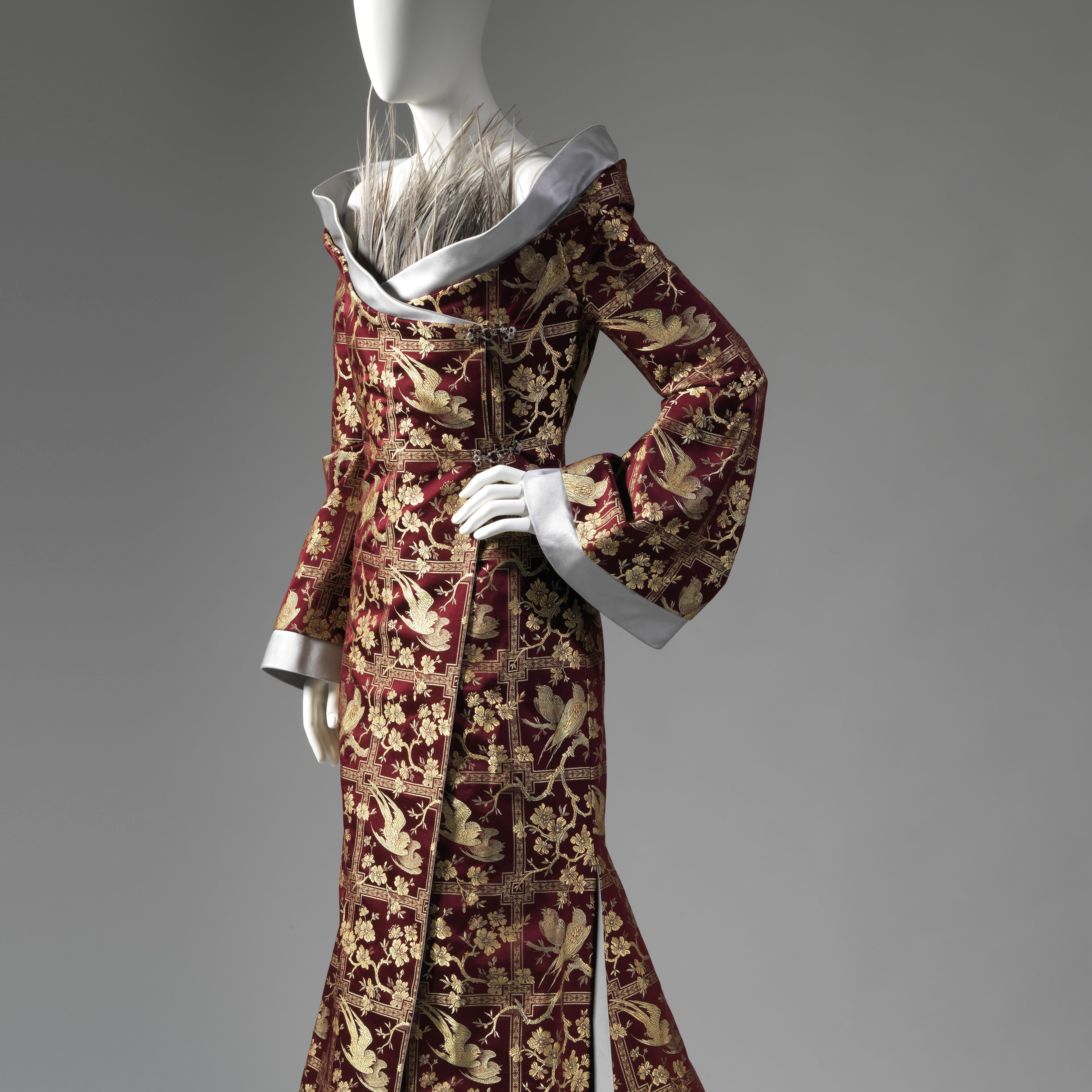 Detail view of an elegant red-and-gold ensemble by Alexander McQueen