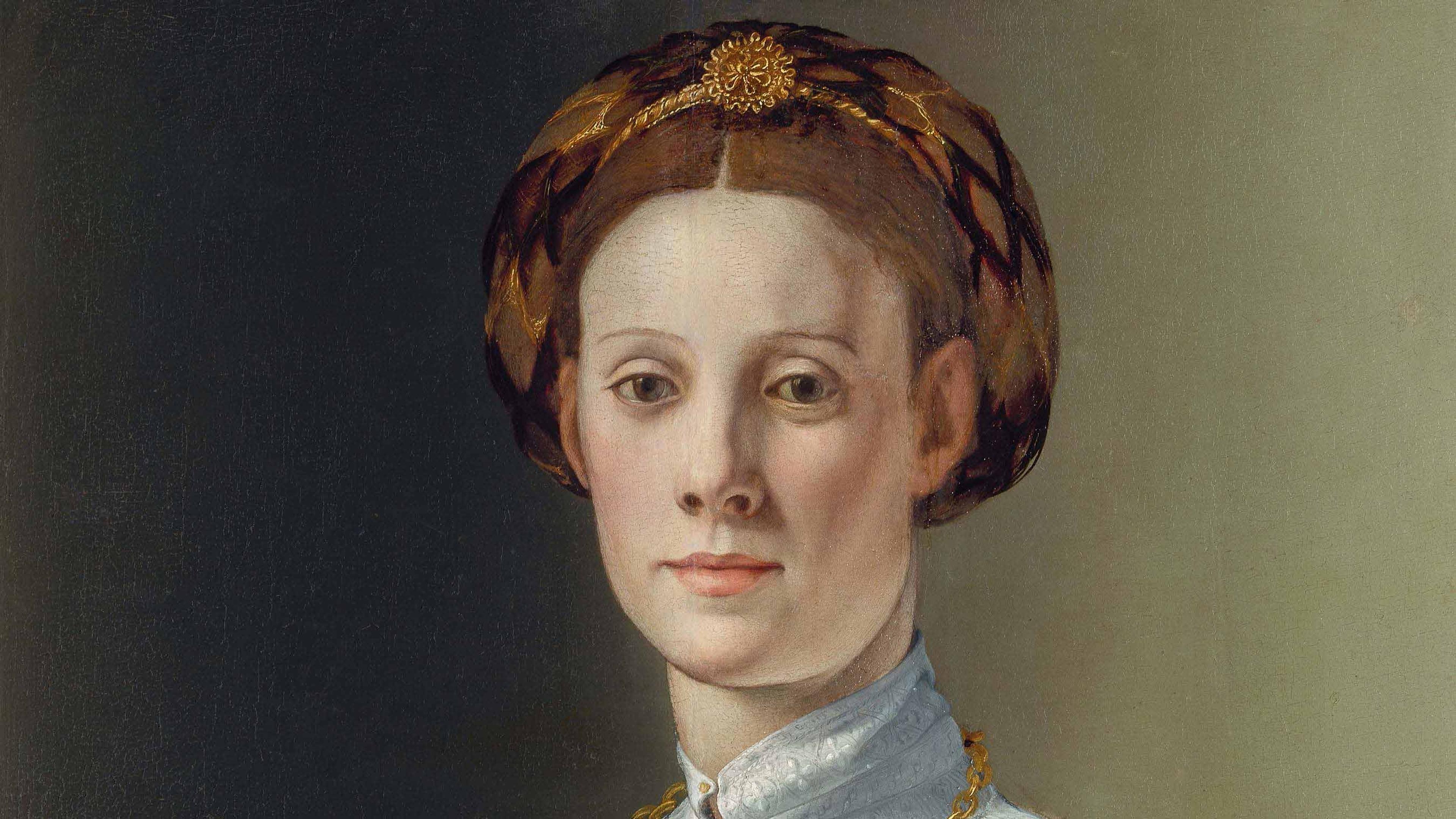Detail from Portrait of a Woman with a Lapdog by Branzino. A painting of an ornately dressed woman with a small dog in her lap.