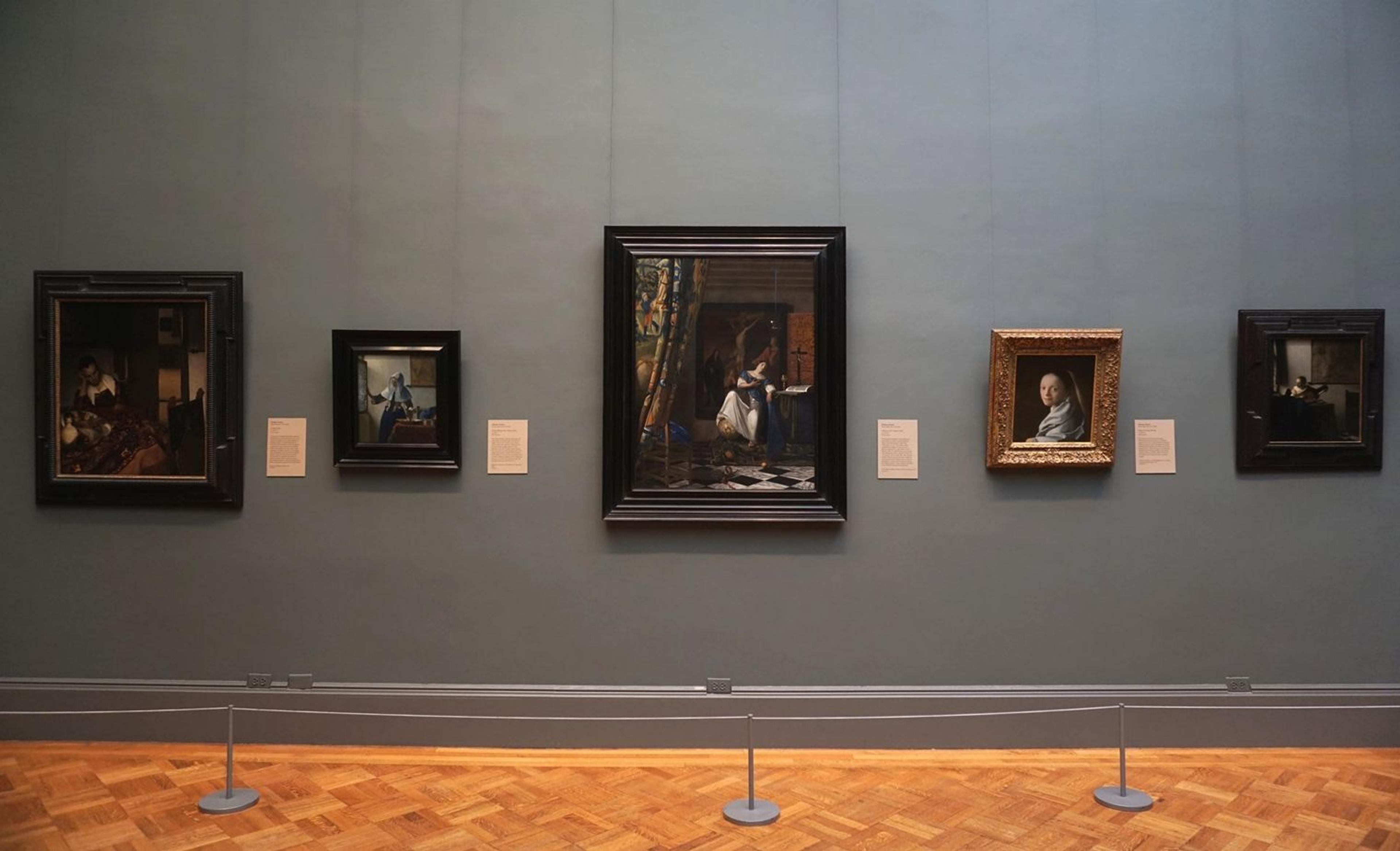 View of a Met gallery wall showing three masterpiece paintings by Johannes Vermeer