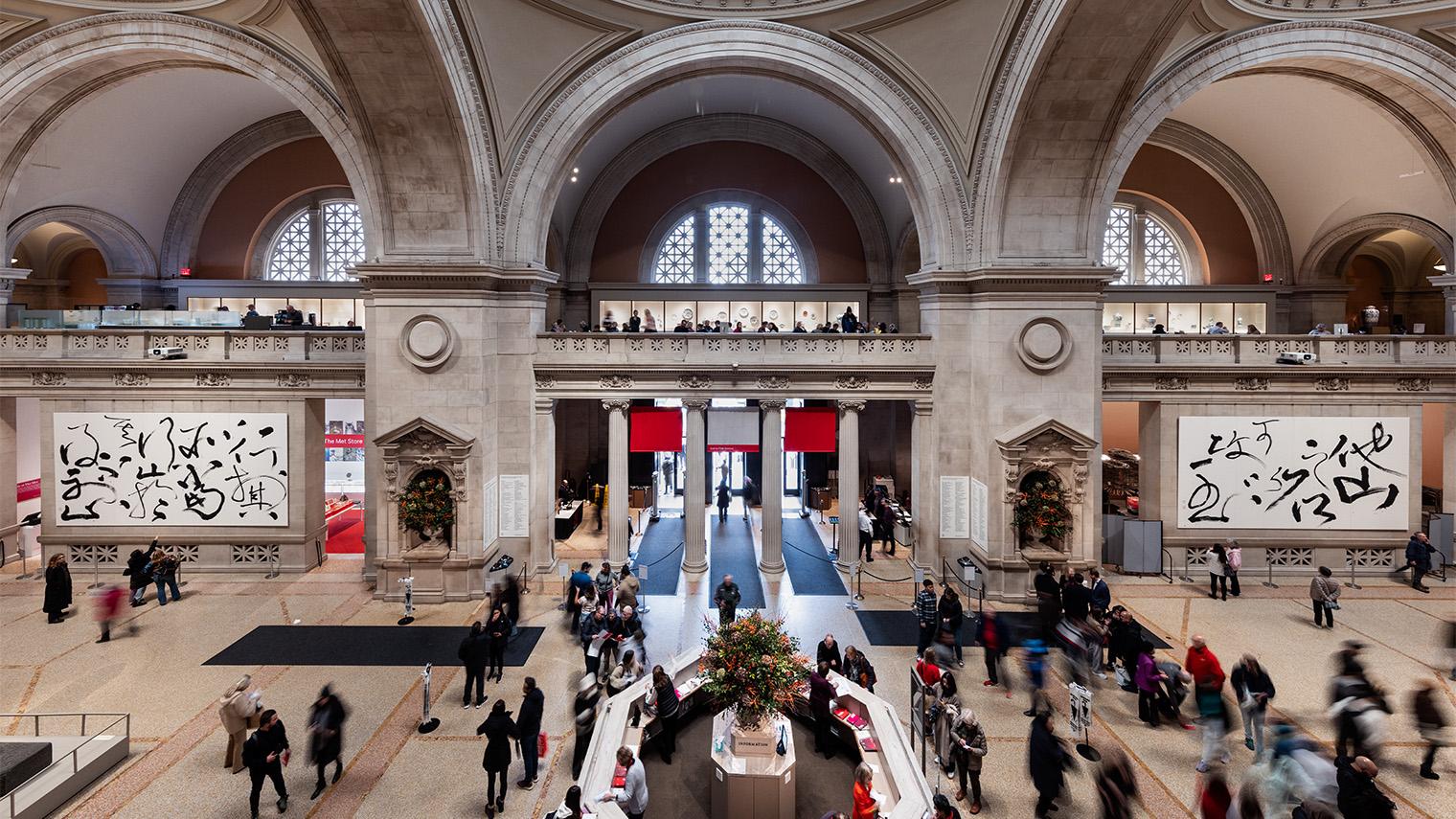 Photo image of The Great Hall of the Met, with hanging calligraphy paintings