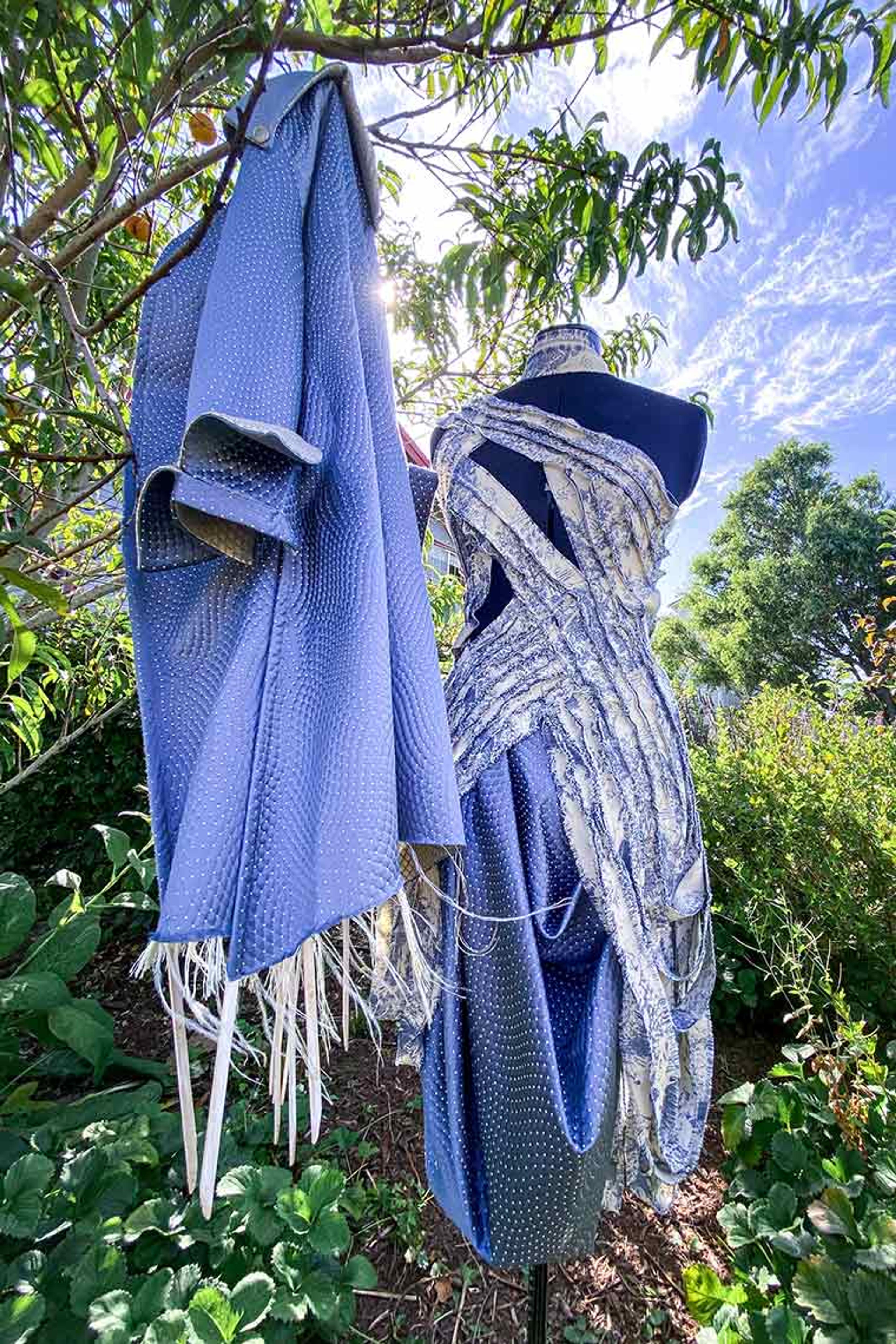 Parker Spear's blue dress design with matching jacket on display in nature