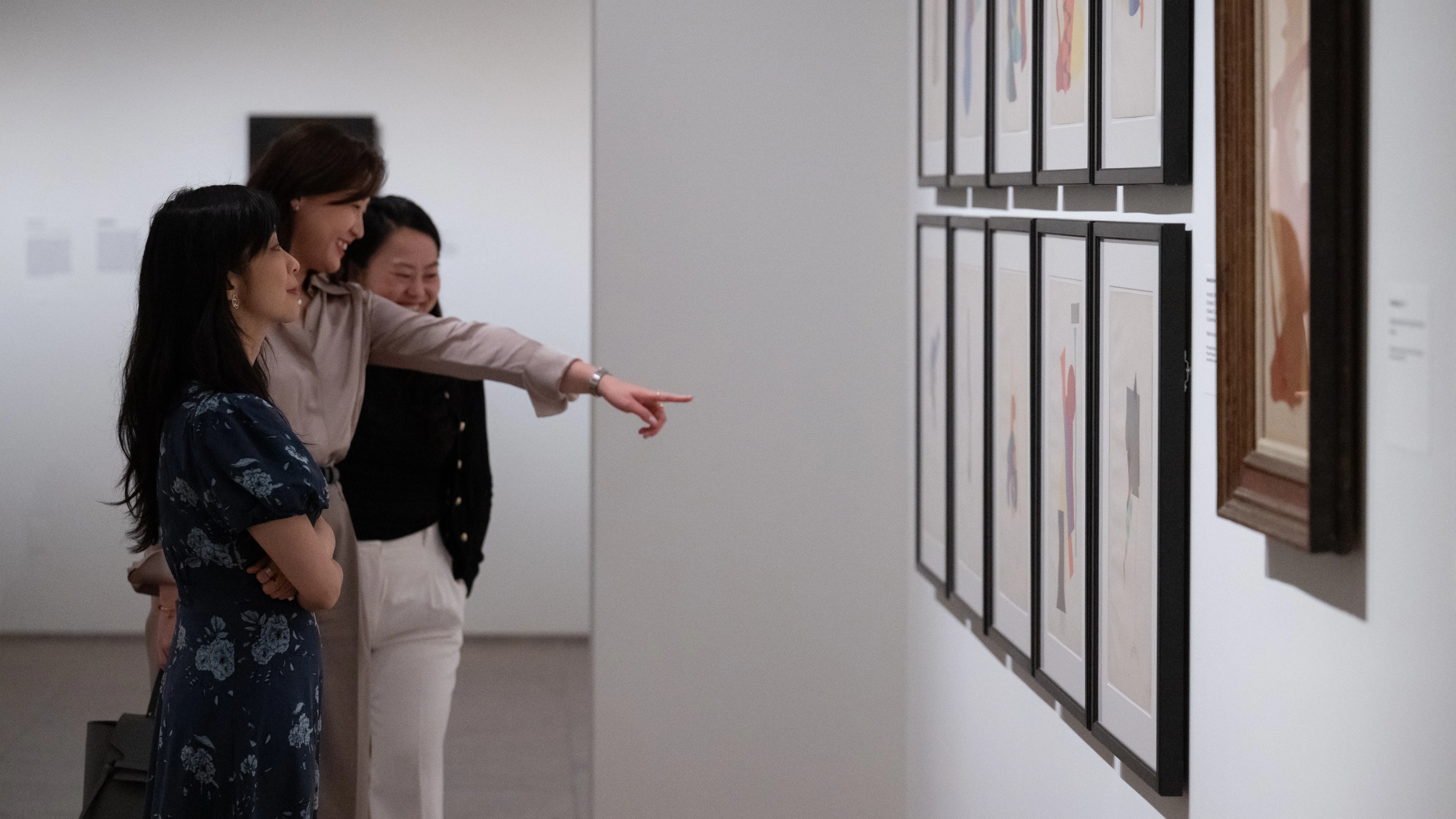 Two people pointing at an artwork and smiling.