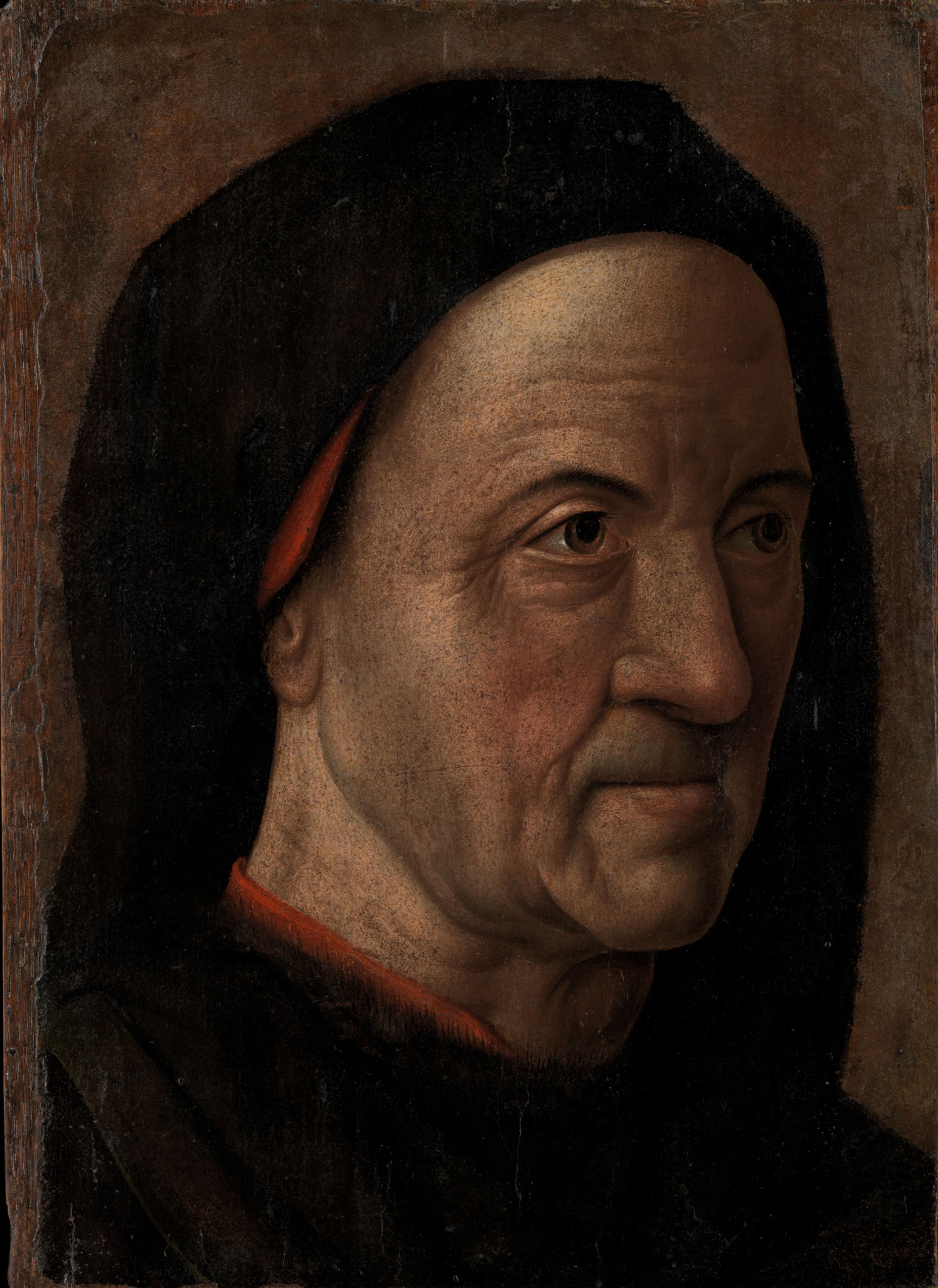 Portrait of a wrinkled old man wearing a black cloak with a red garment underneath, in front of a brown background.