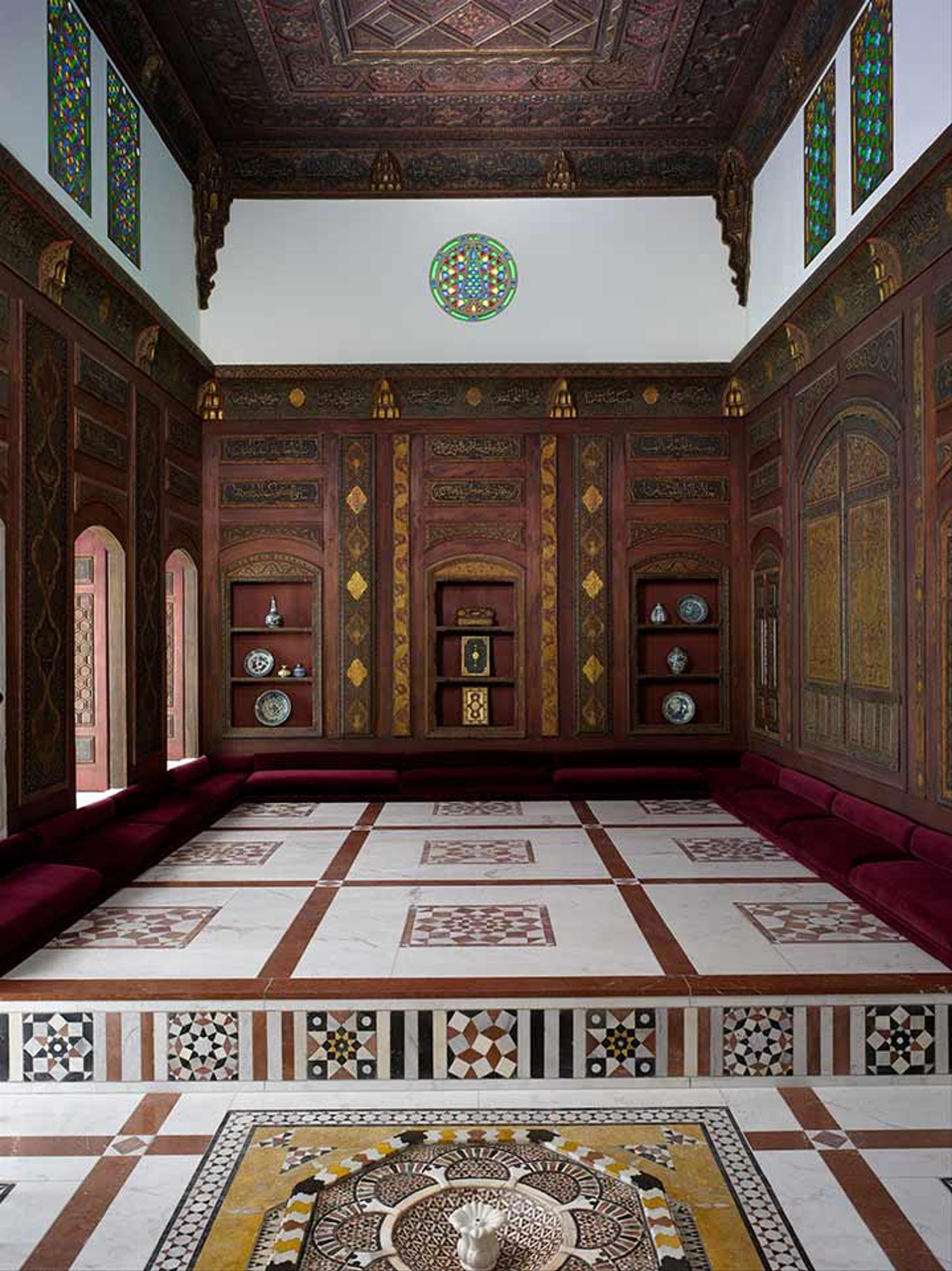 View of room with inlaid wood-paneled walls and geometrically patterned white floors