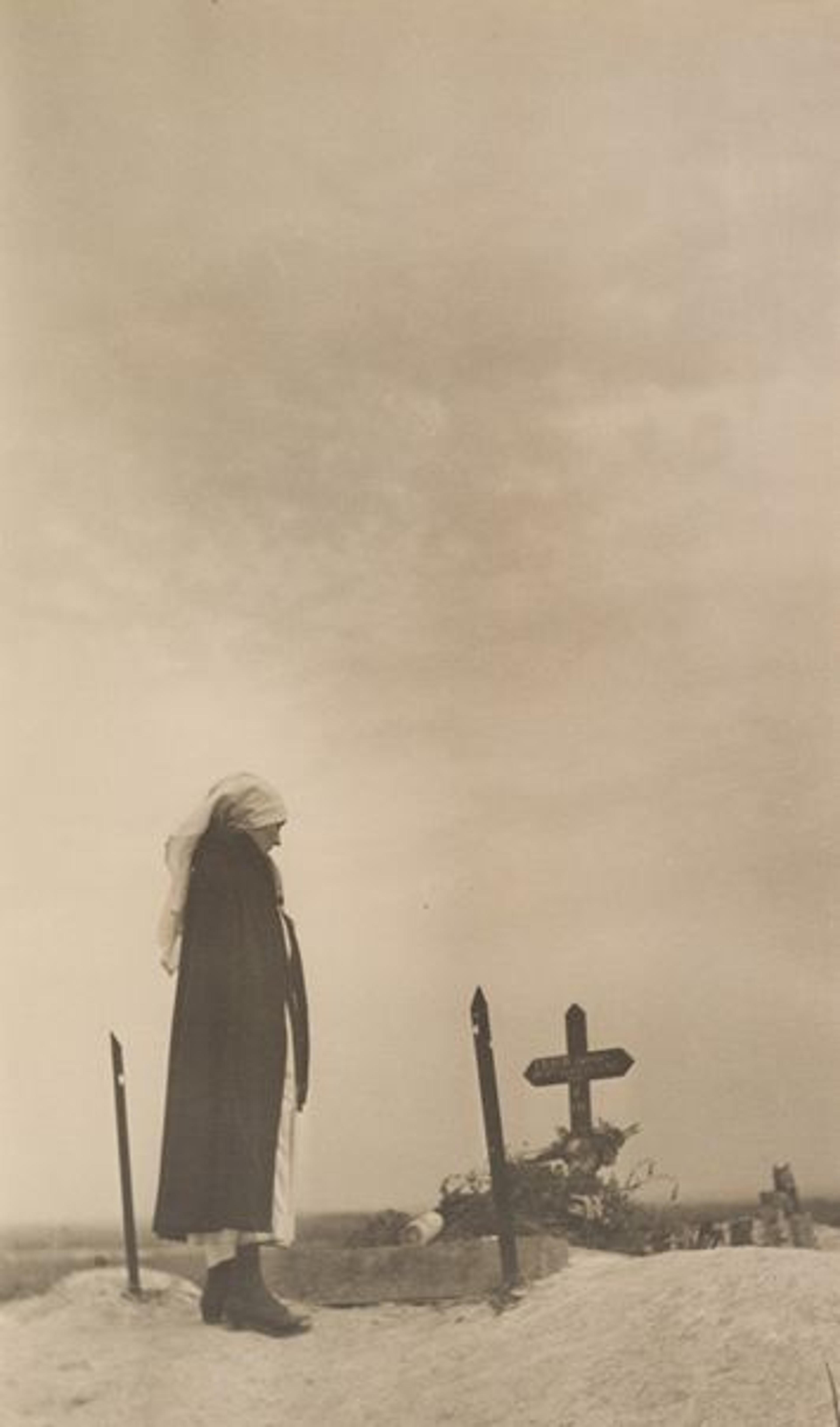 Photo by Margaret Hall of a woman standing over an unmarked grave in 'No-Man's-Land'