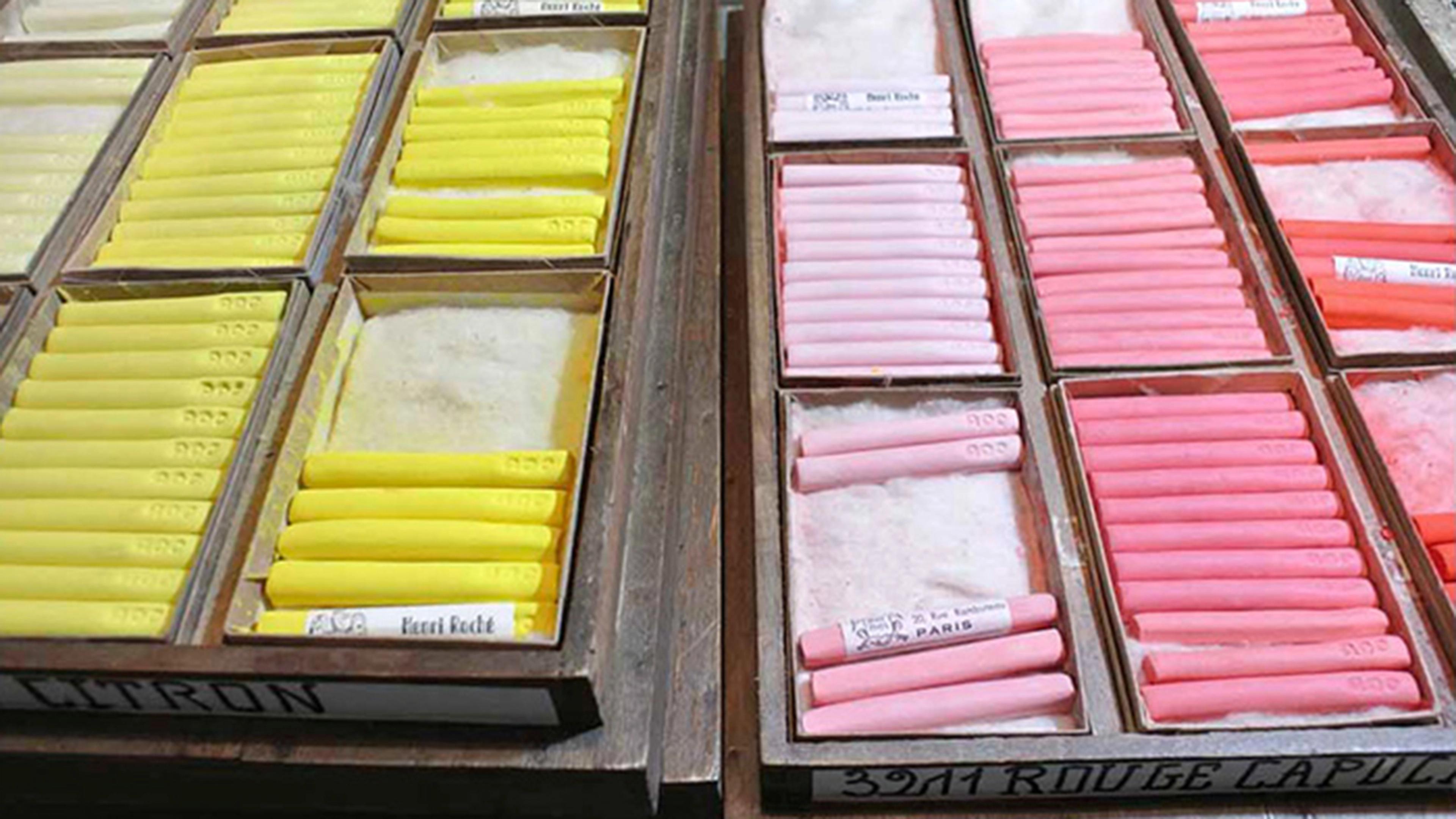 Wooden boxes contain pastel sticks in yellow and pink gradients