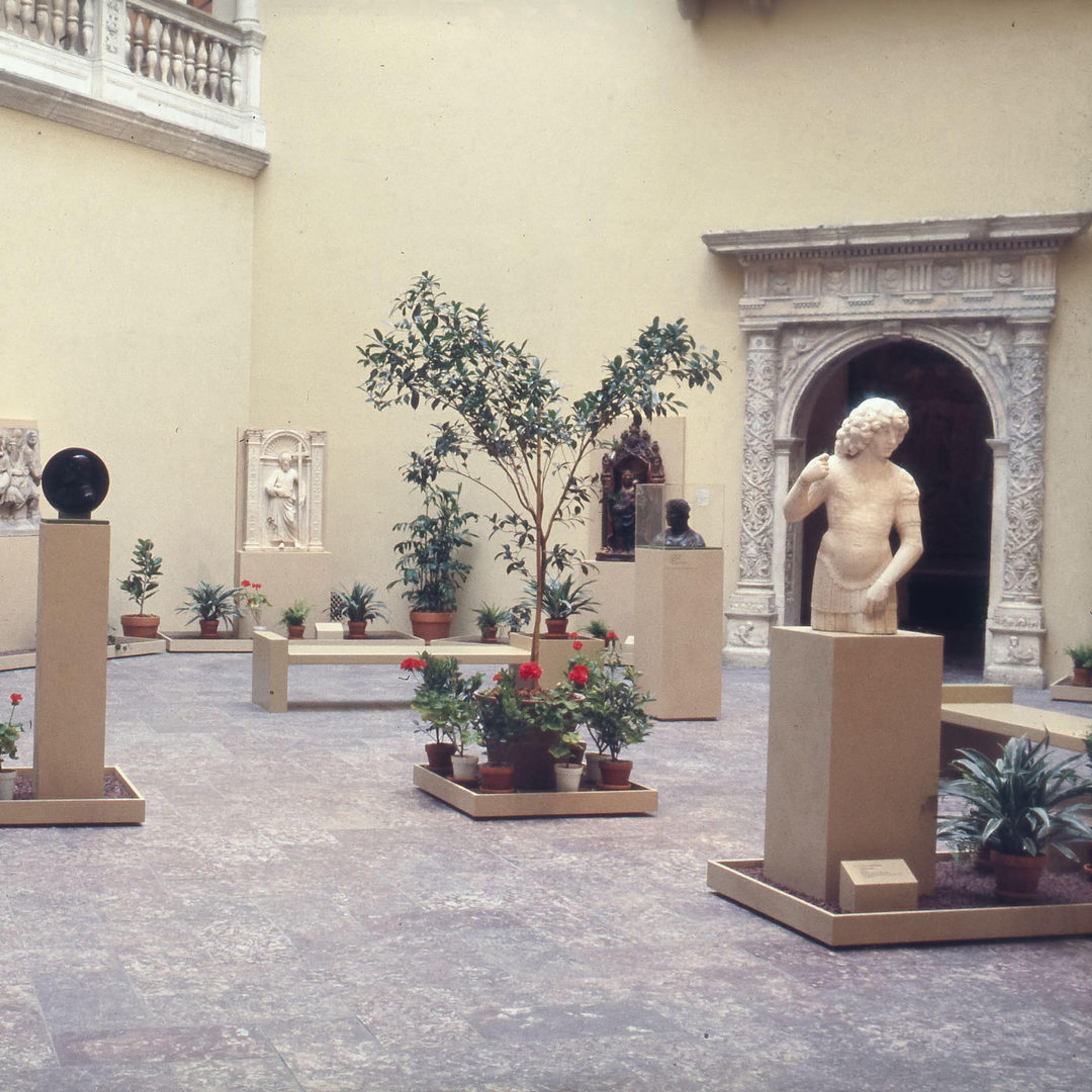 An interior courtyard featuring sculptures and potted plants
