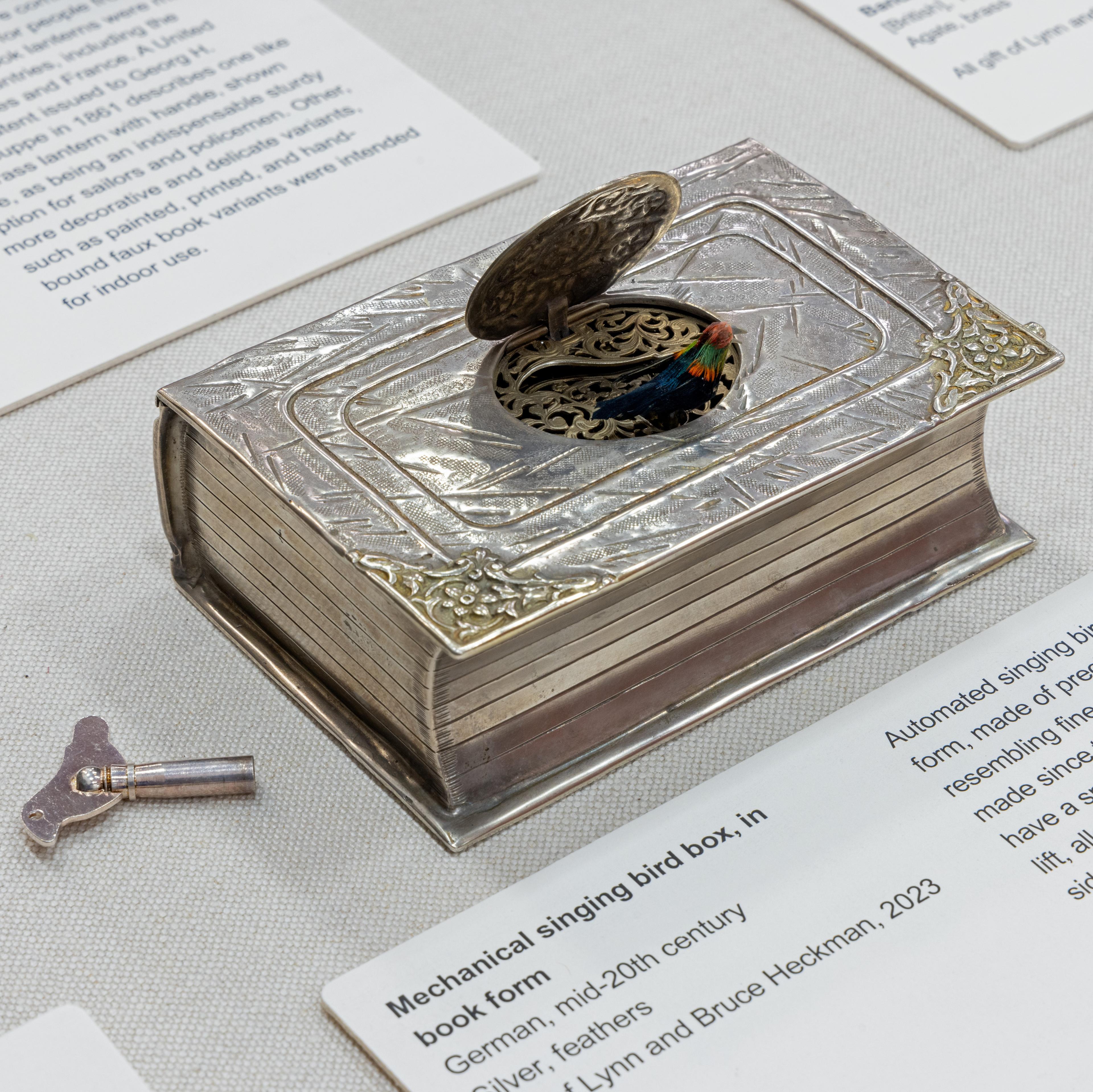 An intricately carved white stone plaque showcasing a floral design with a prominent central flower, detailed leaves, and a bow, set against a textured backdrop, displaying fine craftsmanship.