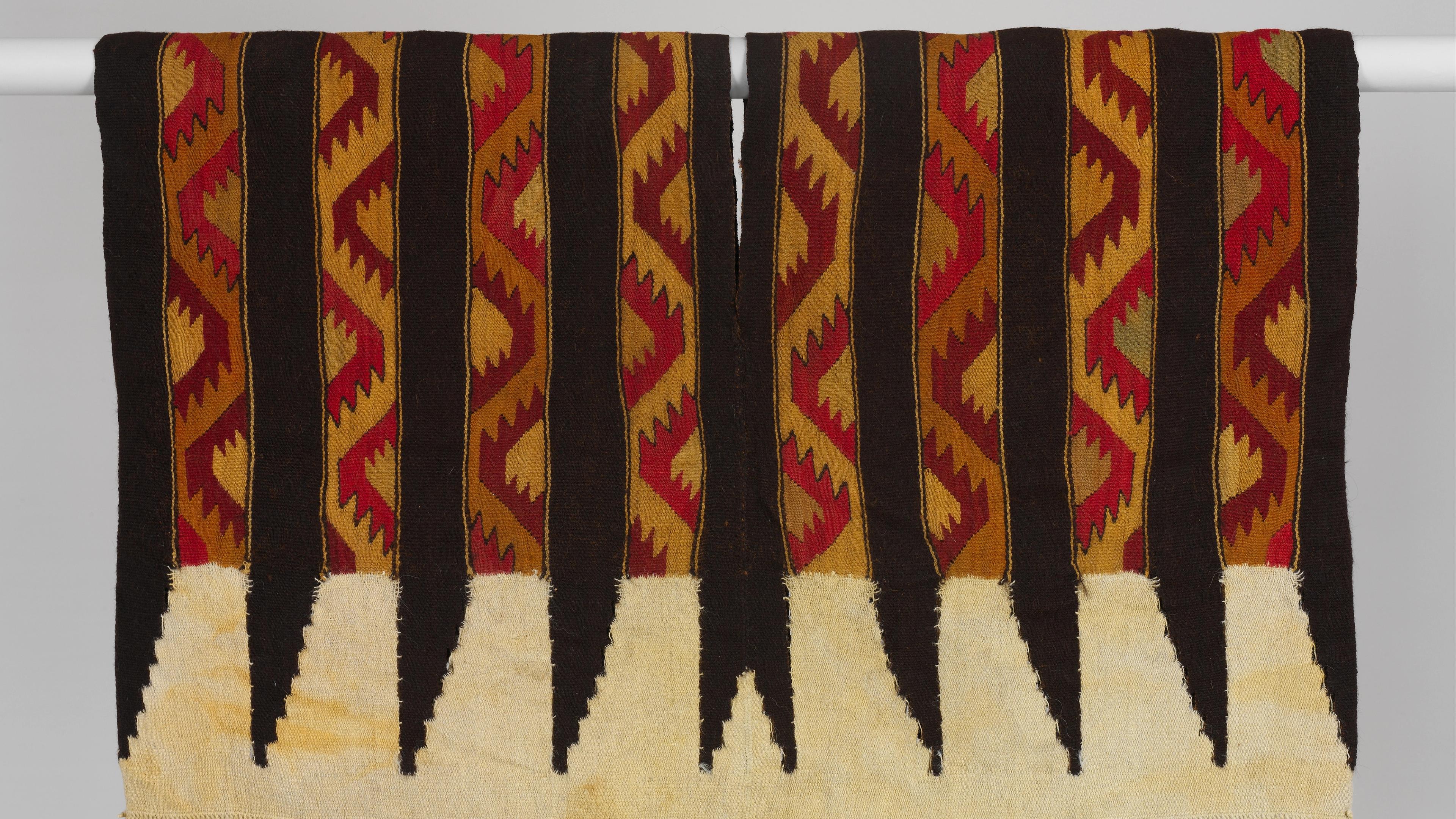 Tunic with jagged patterns in red, gold, and black