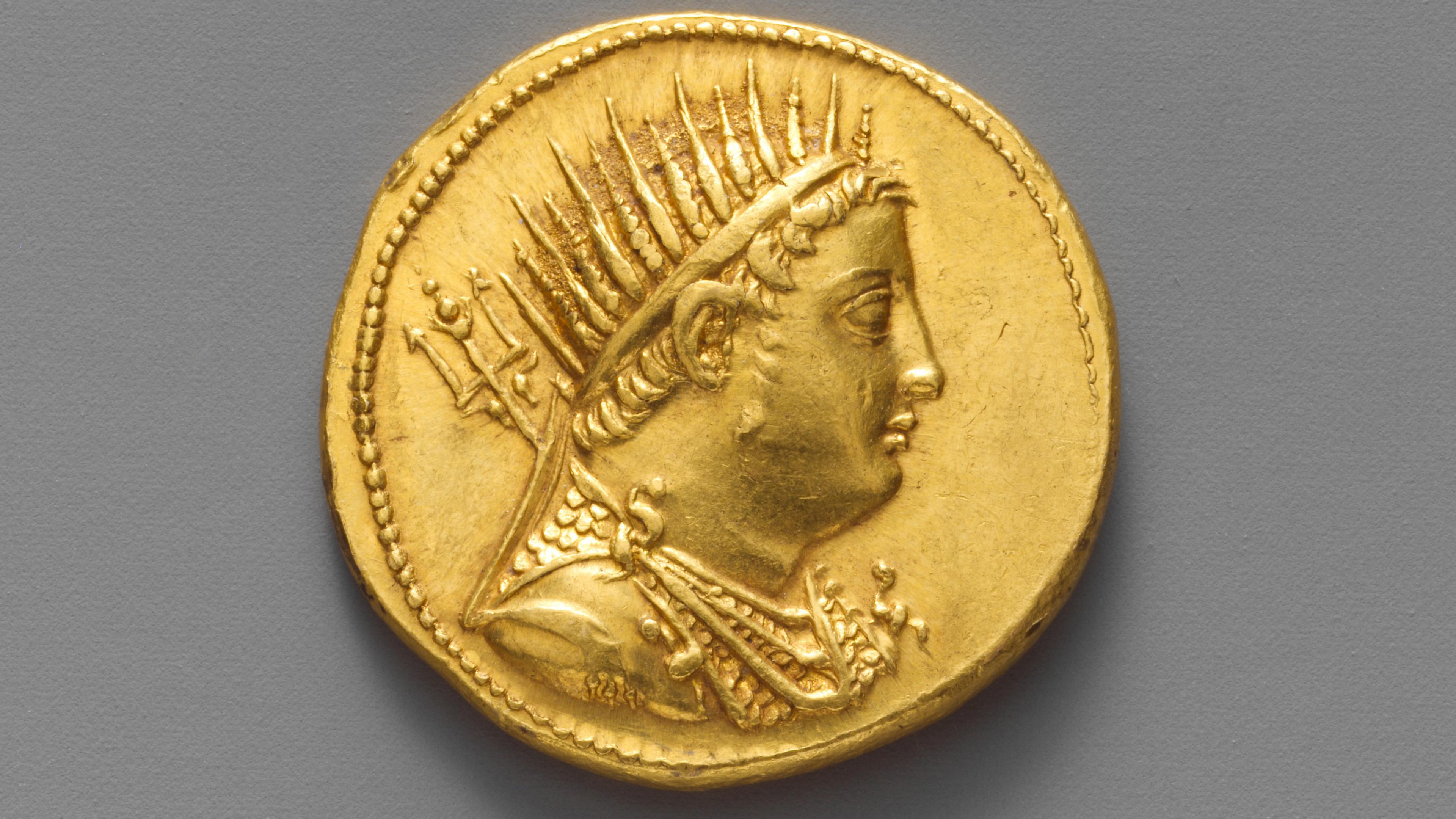 profile of man wearing a spiked headpiece on a gold coin