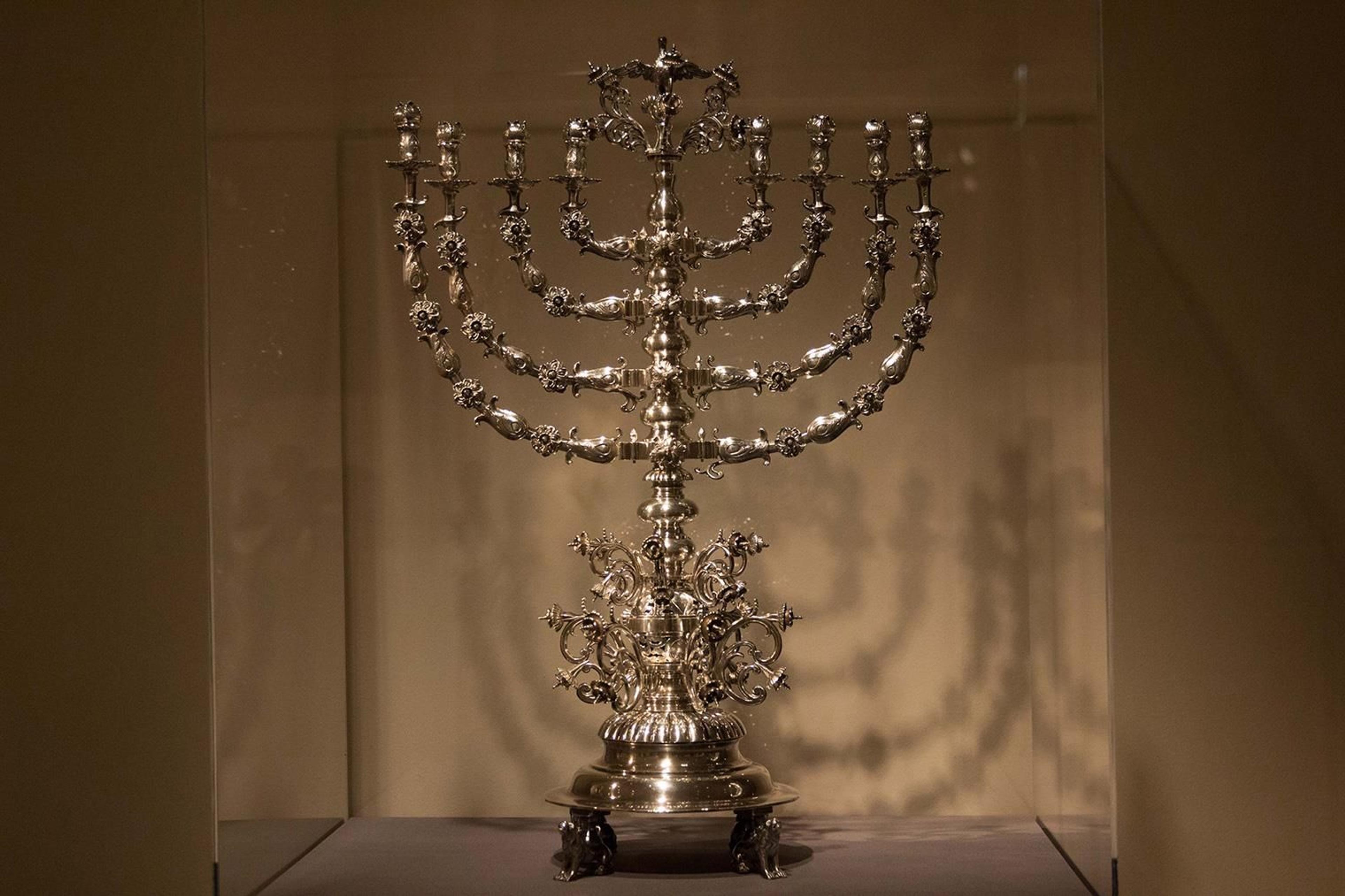 Picture of a fancy menorah made of silver with floral details.