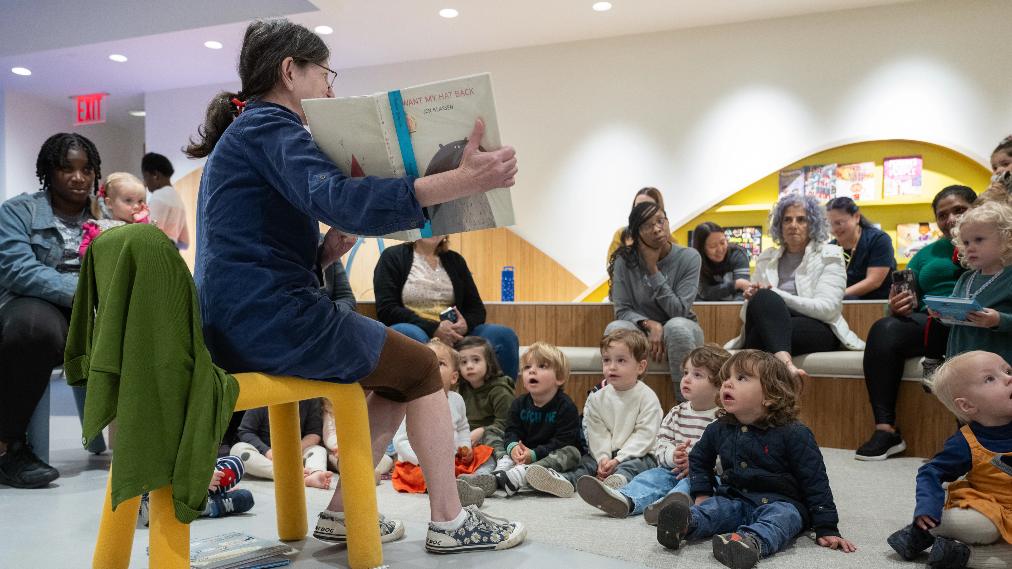 An educator reads a book to a group of children. 