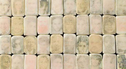10 columns and four rows of rectangular bars of soap with faded faces on each bar