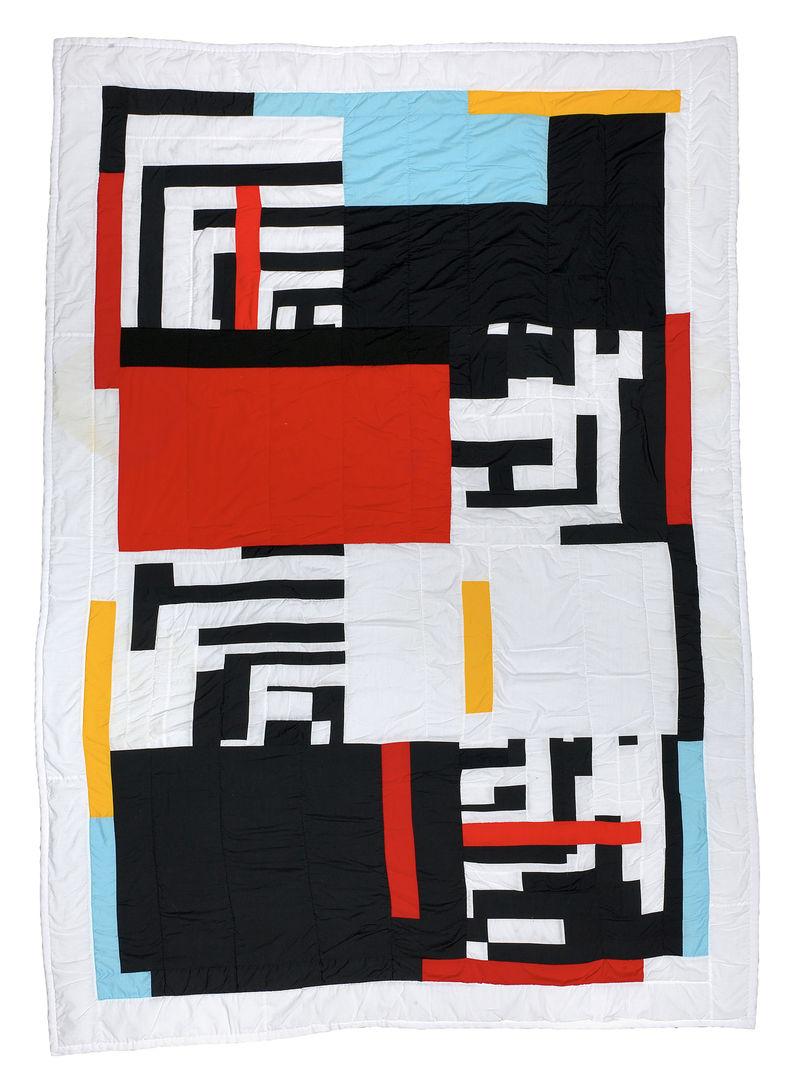 Quilt with black and striking primary colors against a white background. Shapes include both blocky and narrow rectangles, as well as squares with maze-like patterns.