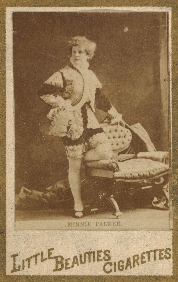 Detail view of a 1887 trading card featuring the actress Minnie Palmer. She poses with one hand on her hip, staring off to her right.