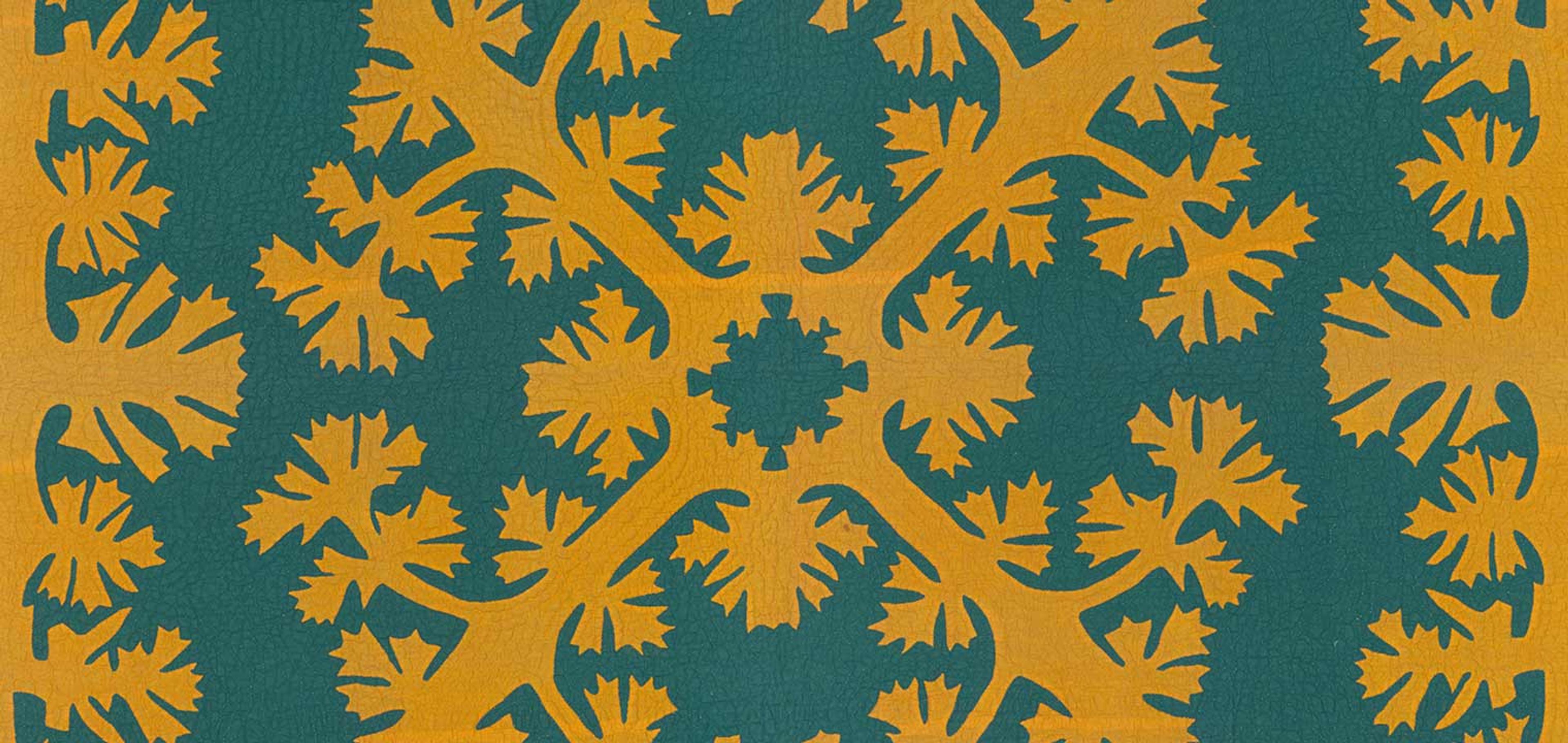A teal quilt with yellow fringe and a symmetrical yellow design in its center. Both the center and edge designs feature complex, ornate, flower blossom-like patterns that extend identically into all four corners of the quilt.