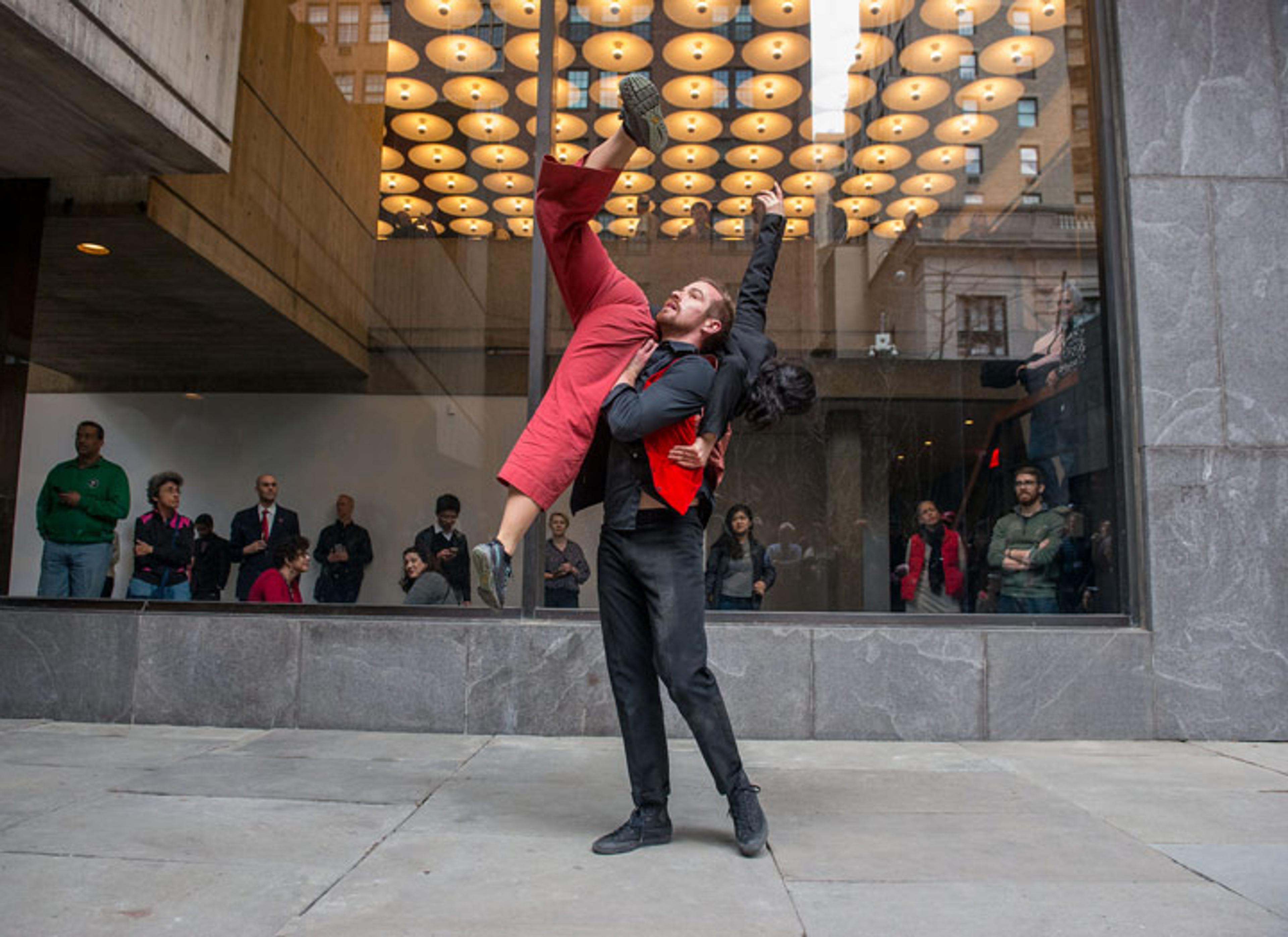 A male dancer supports a female dancer while performing in The Met Breuer's Sunken Garden