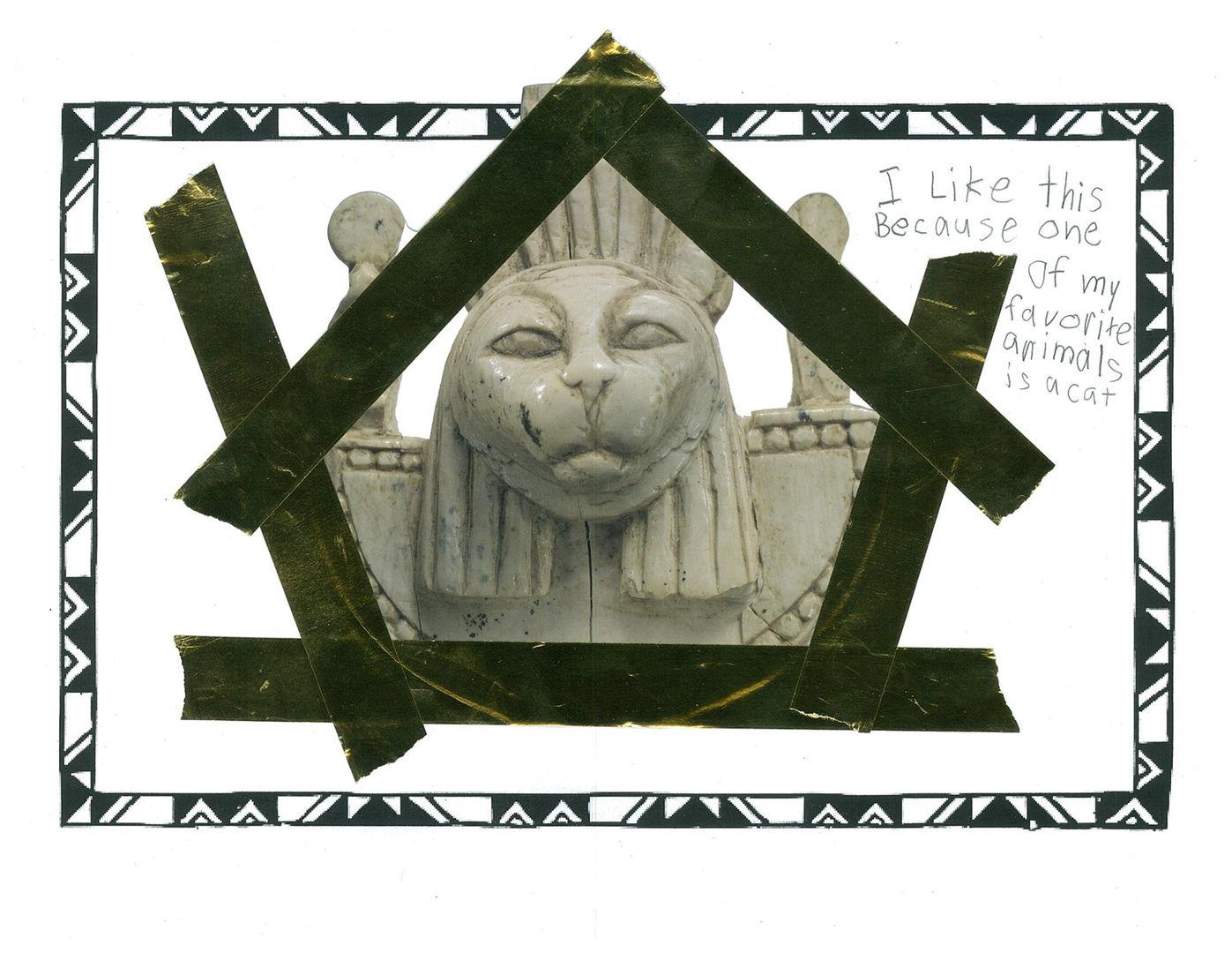 Picture of a kid's love letter to an ivory carving with a sculpted cat head wearing a collar. The kid has decorated the love note with gold tape.