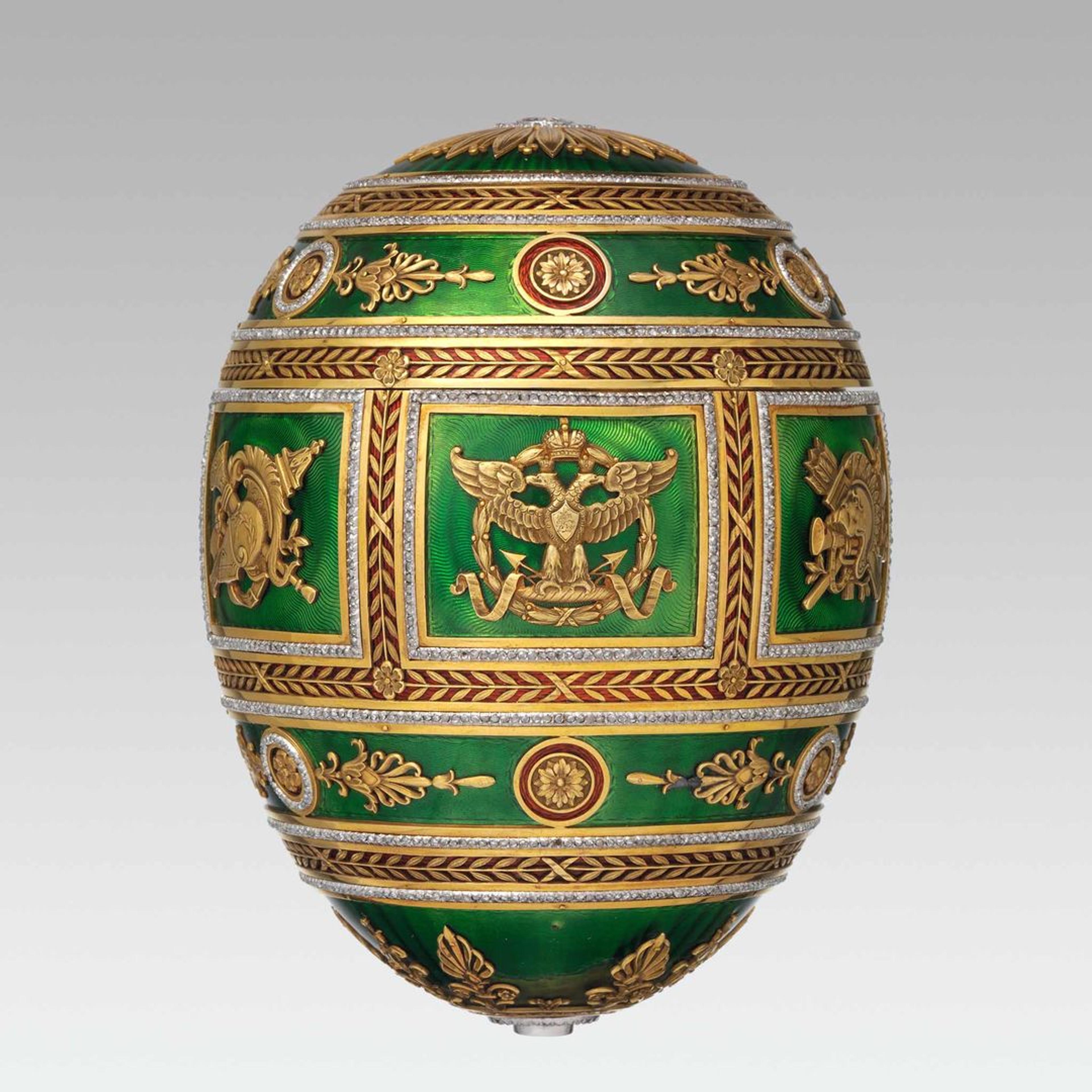 Ornately decorated green egg with gold detailing and intricate designs.