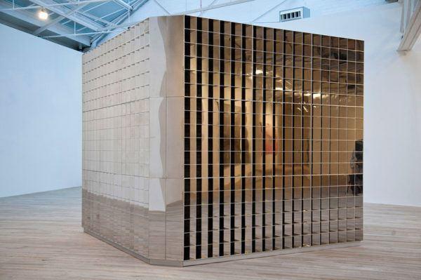 a large-scale sculpture of an architectural cube with a reflective side by Rashid Rana titled