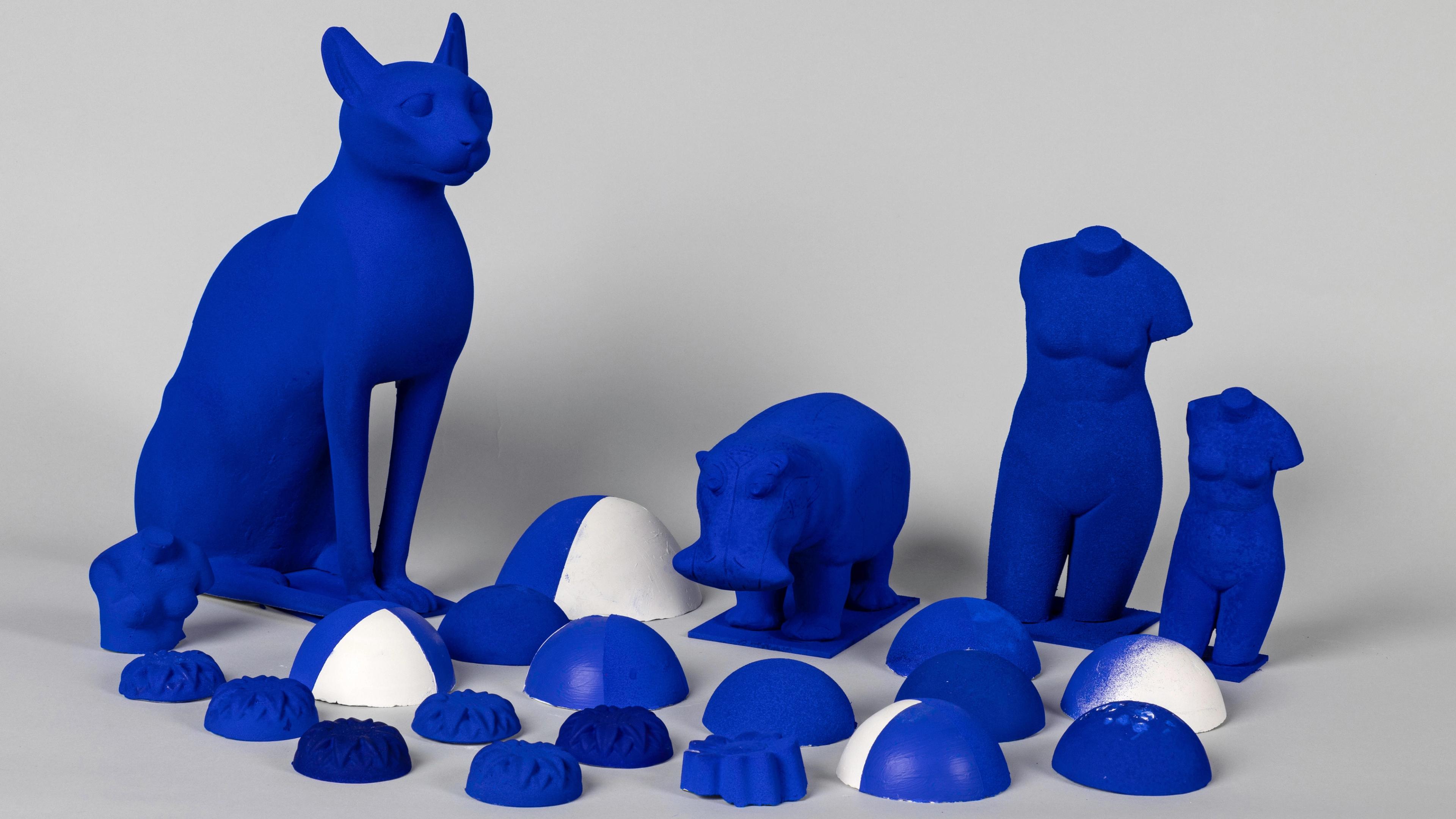 A variety of plaster mock-ups, including a cat, human torsos, and an elephant, sprayed with various recipes of I.K.B., a deep shade of blue.