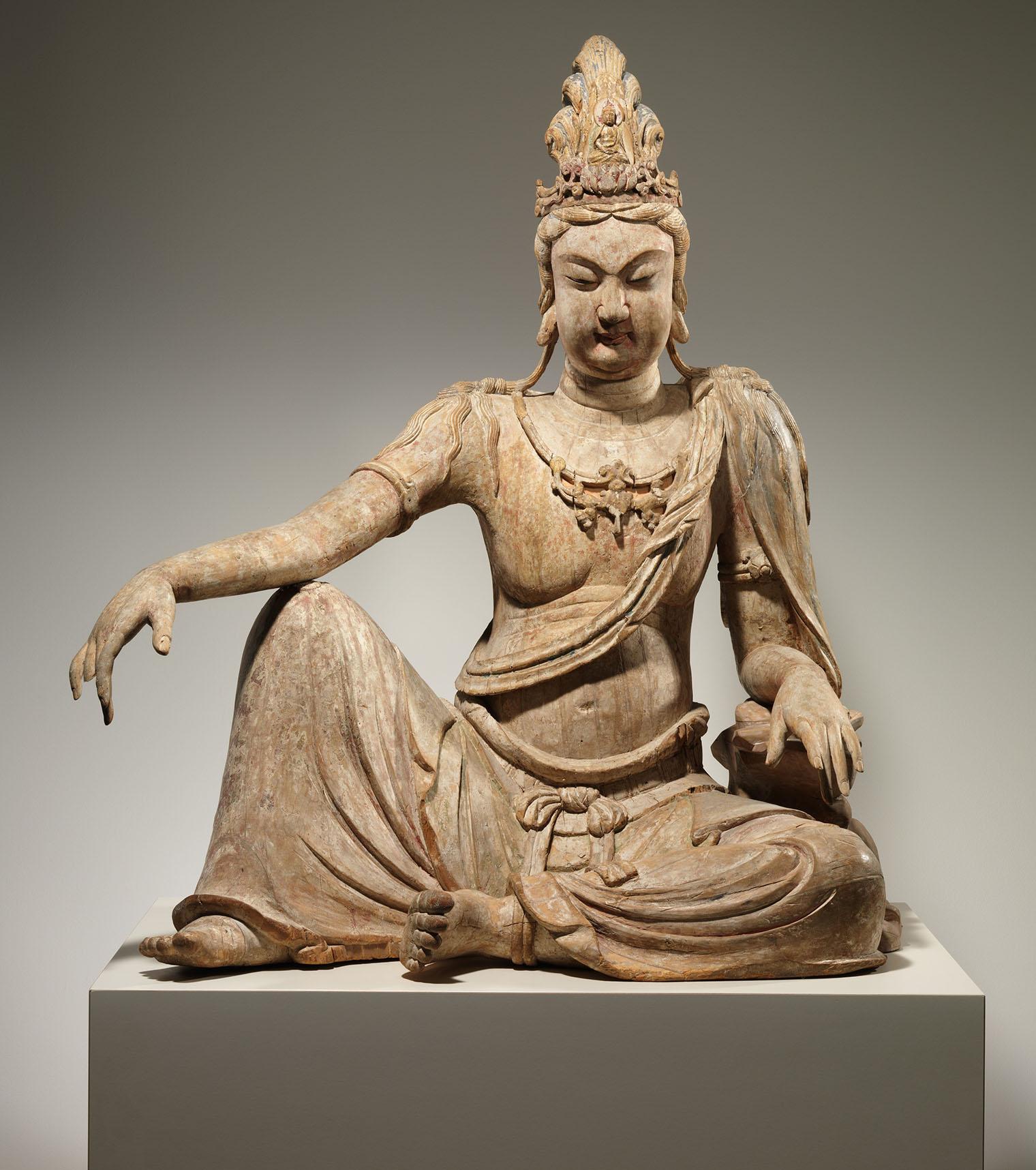 Wooden sculpture of a seated bodhisattva.