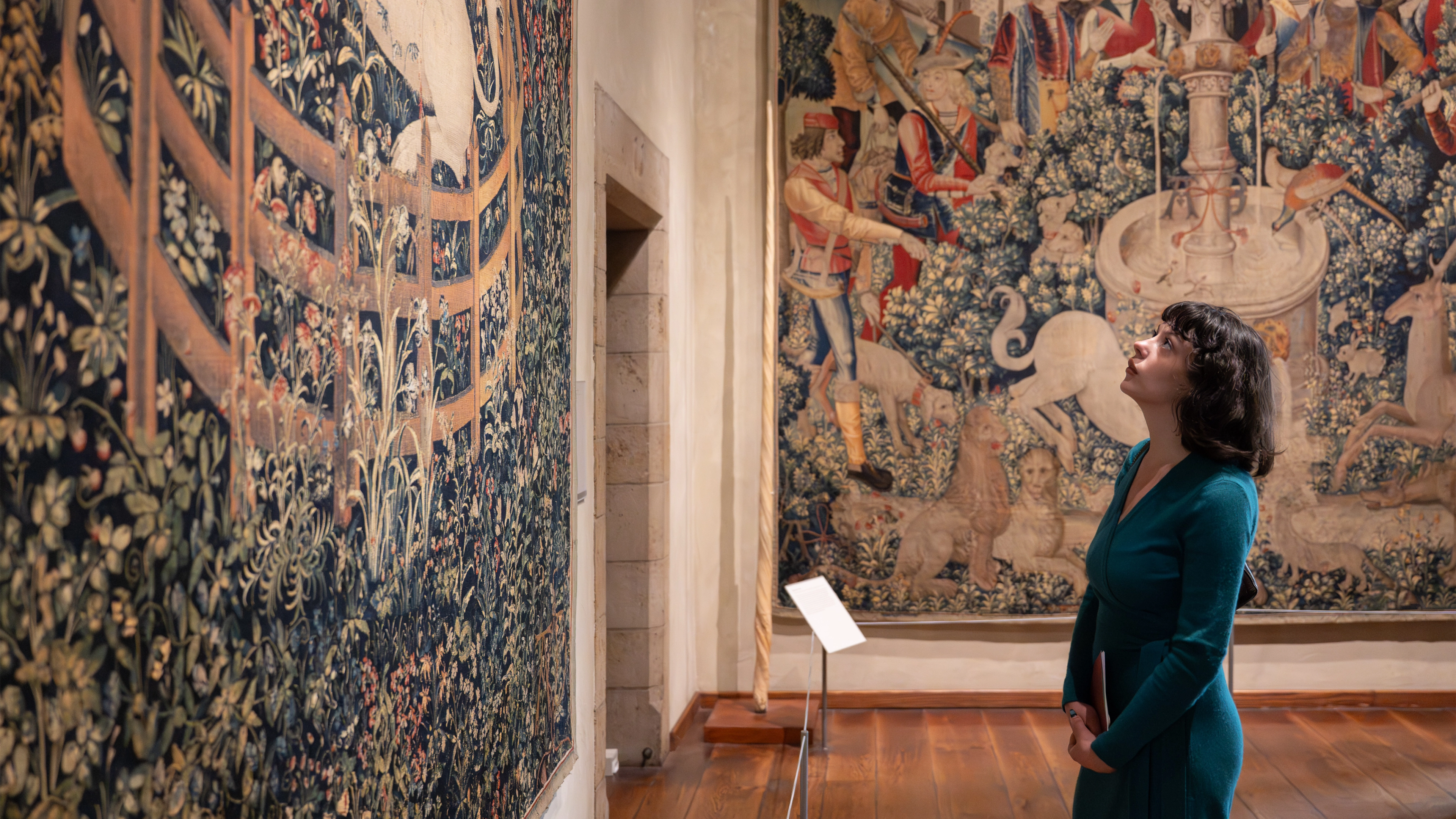 A woman looking at a tapestry at The Met Cloisters. 
