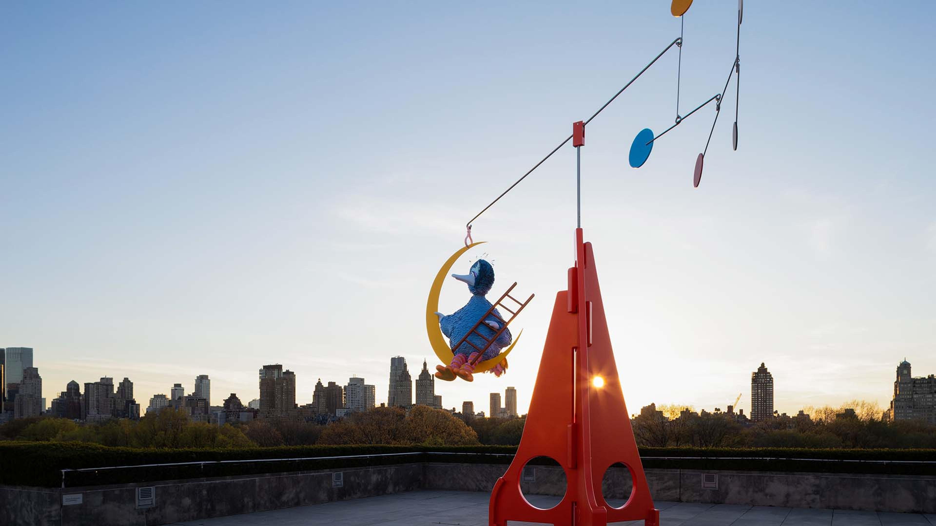 Brightly colored stainless steel, aluminum and fiberglass installation, depicting Sesame Street’s Big Bird swinging on a crescent moon, with the New York skyline on the background. 