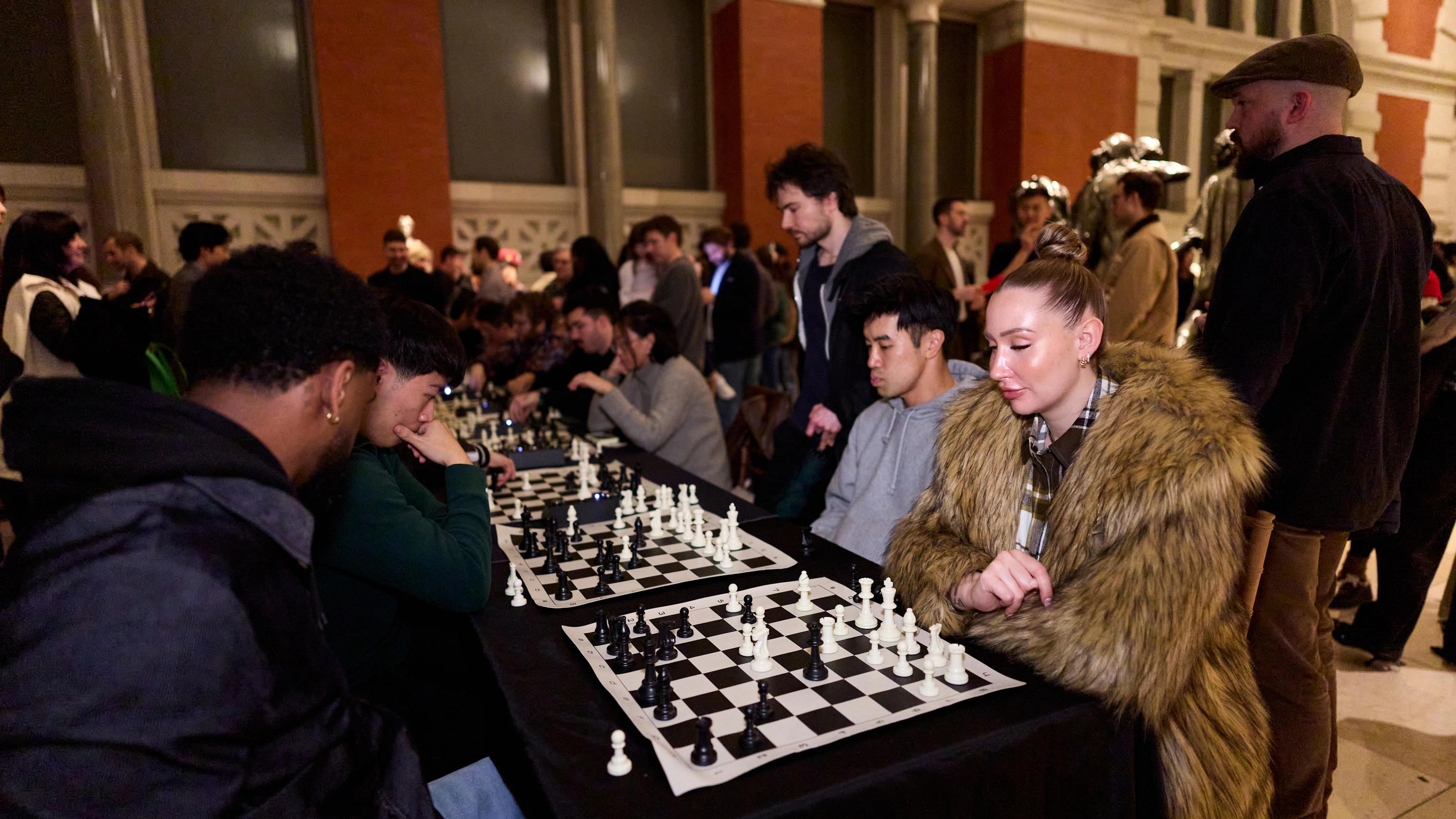 Photograph of a room full of people playing chess.