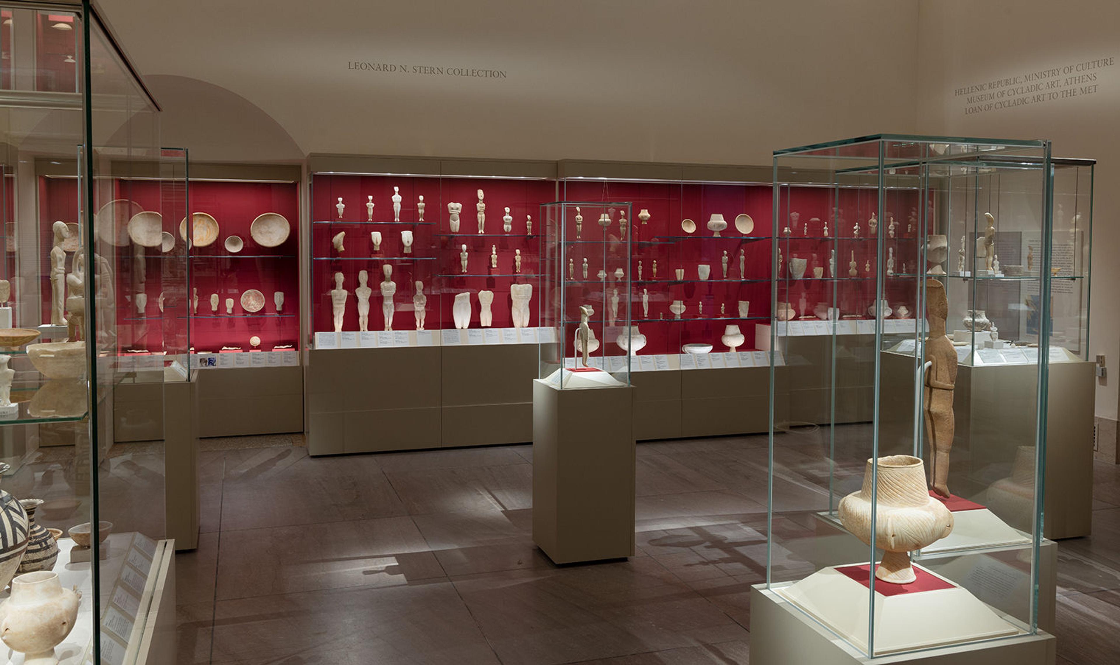 A gallery space filled with Cycladic figures. 
