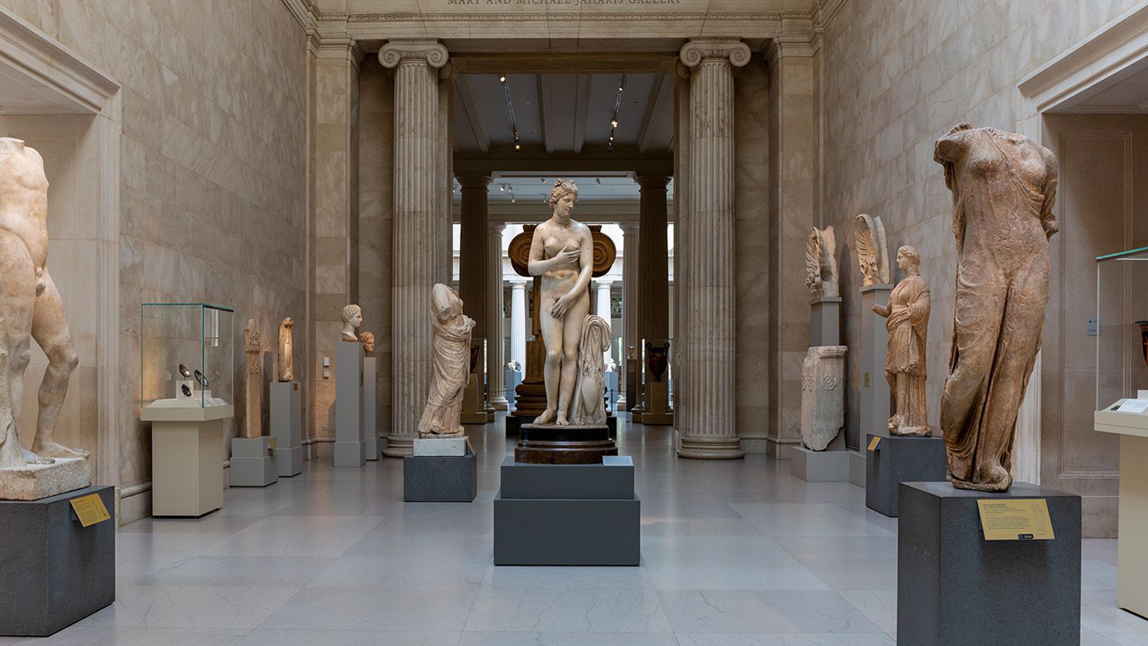 A gallery of Greek and Roman marble statues of humans.