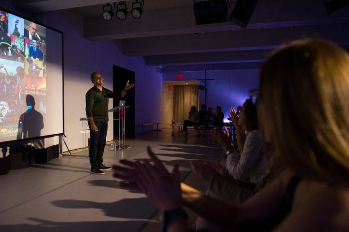 Bassem Youssef speaks to an audience in a small gallery