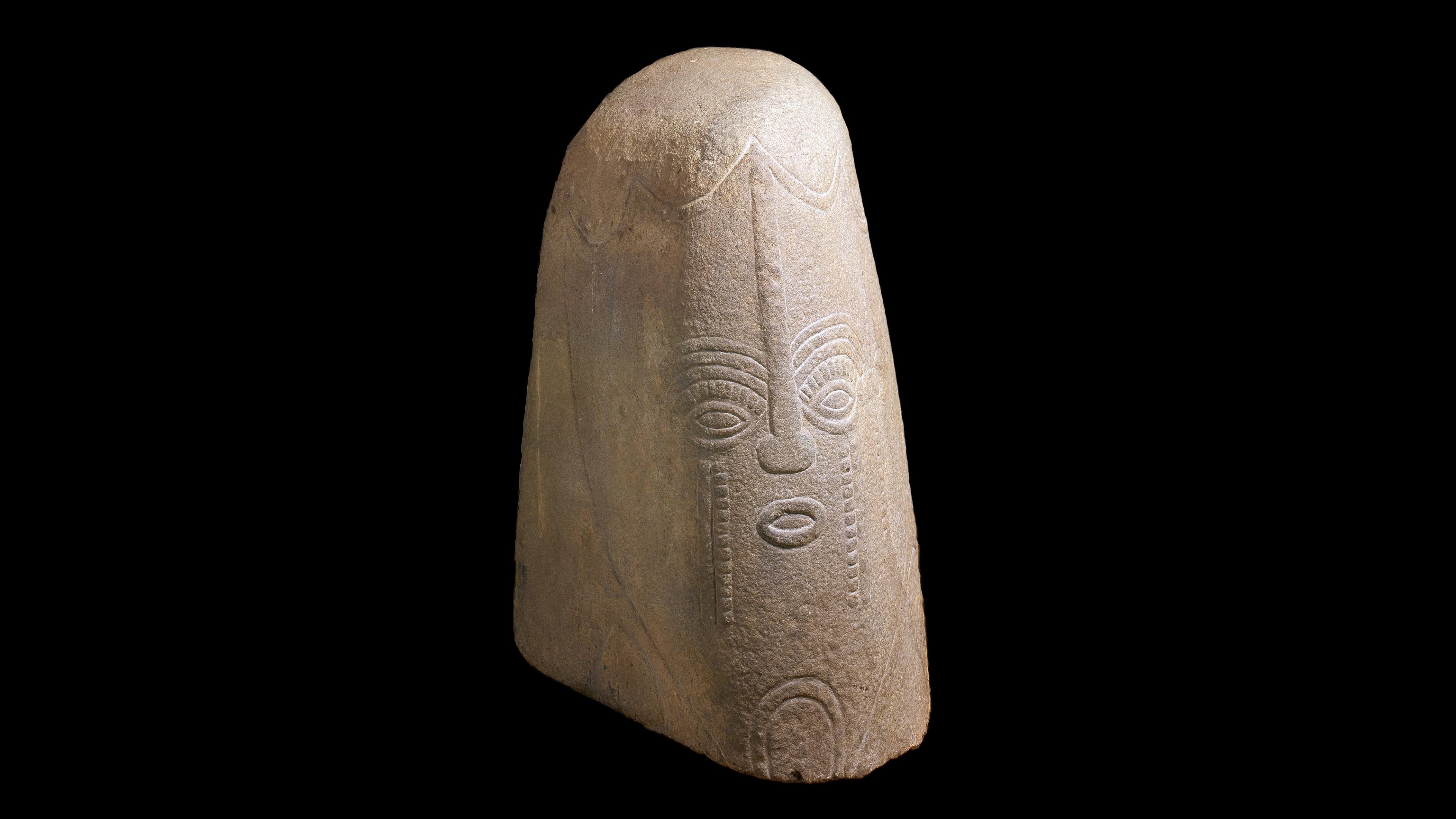 Stone monolith sculpted with low-relief human facial features
