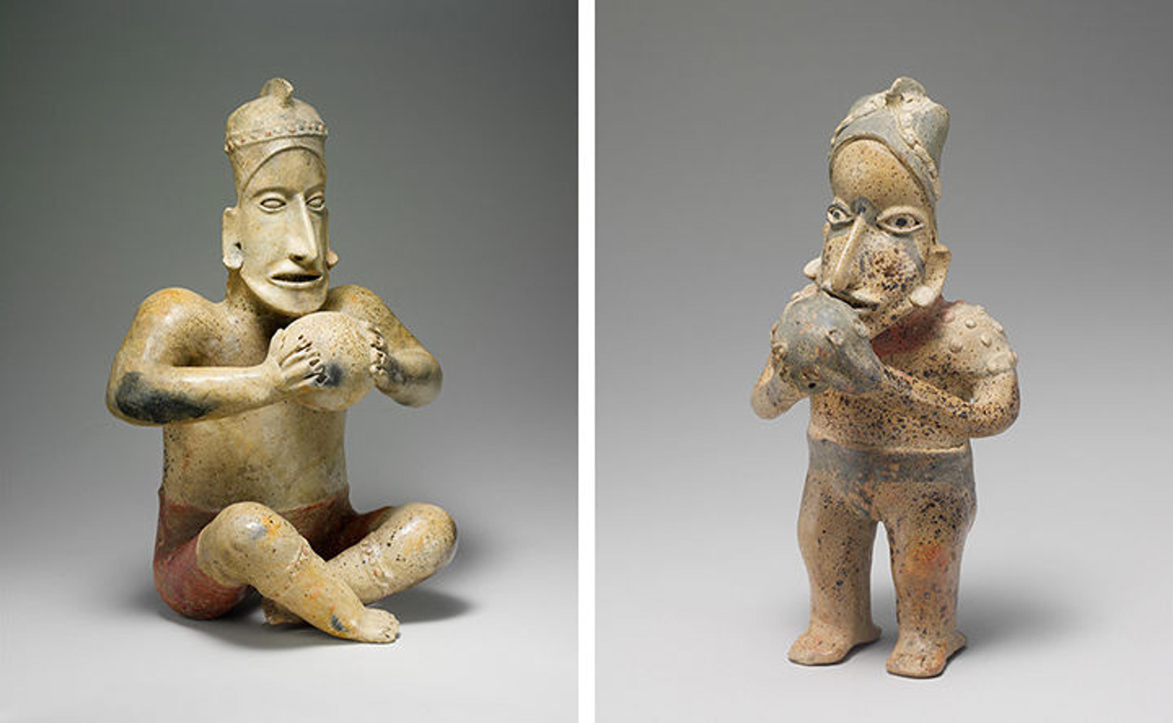 Two ceramic figures, each holding a large ball