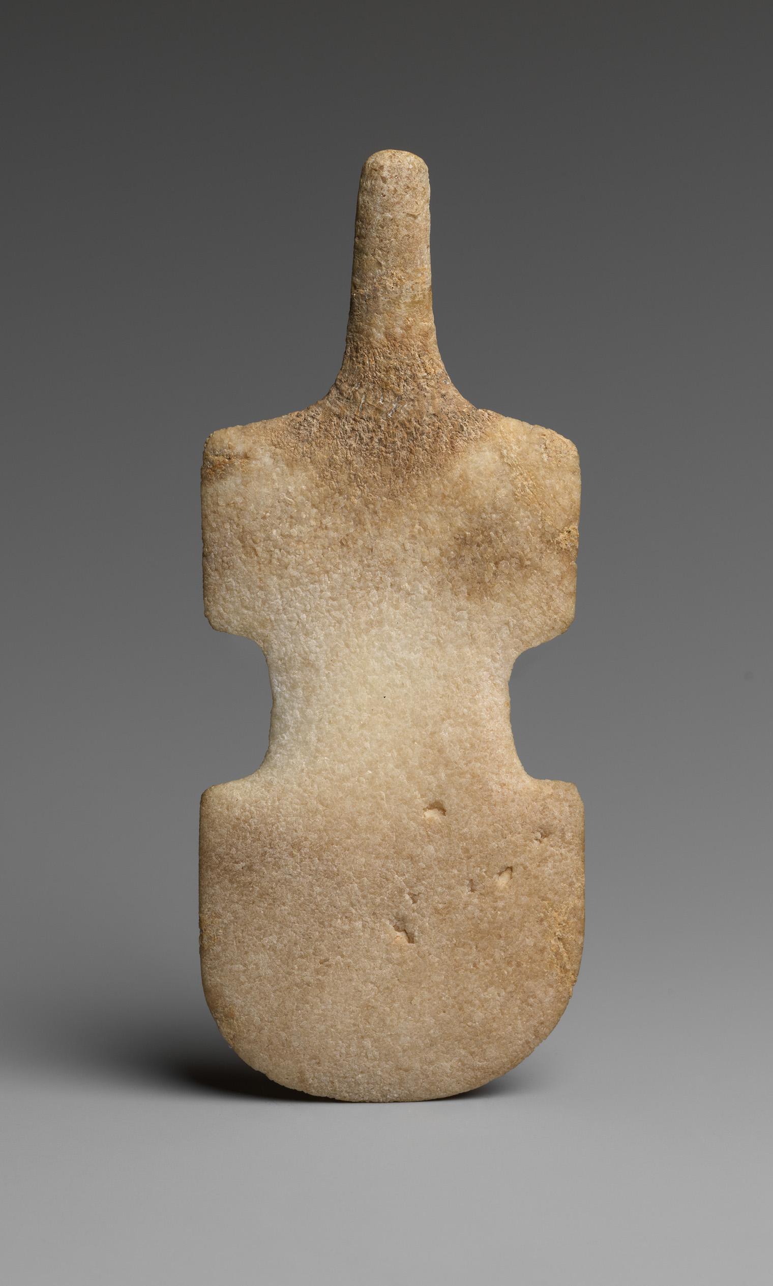 Marble Cycladic figurine with a stylized abstract shape resembling a violin. Its surface has a weathered texture, evoking an ancient, serene aura.